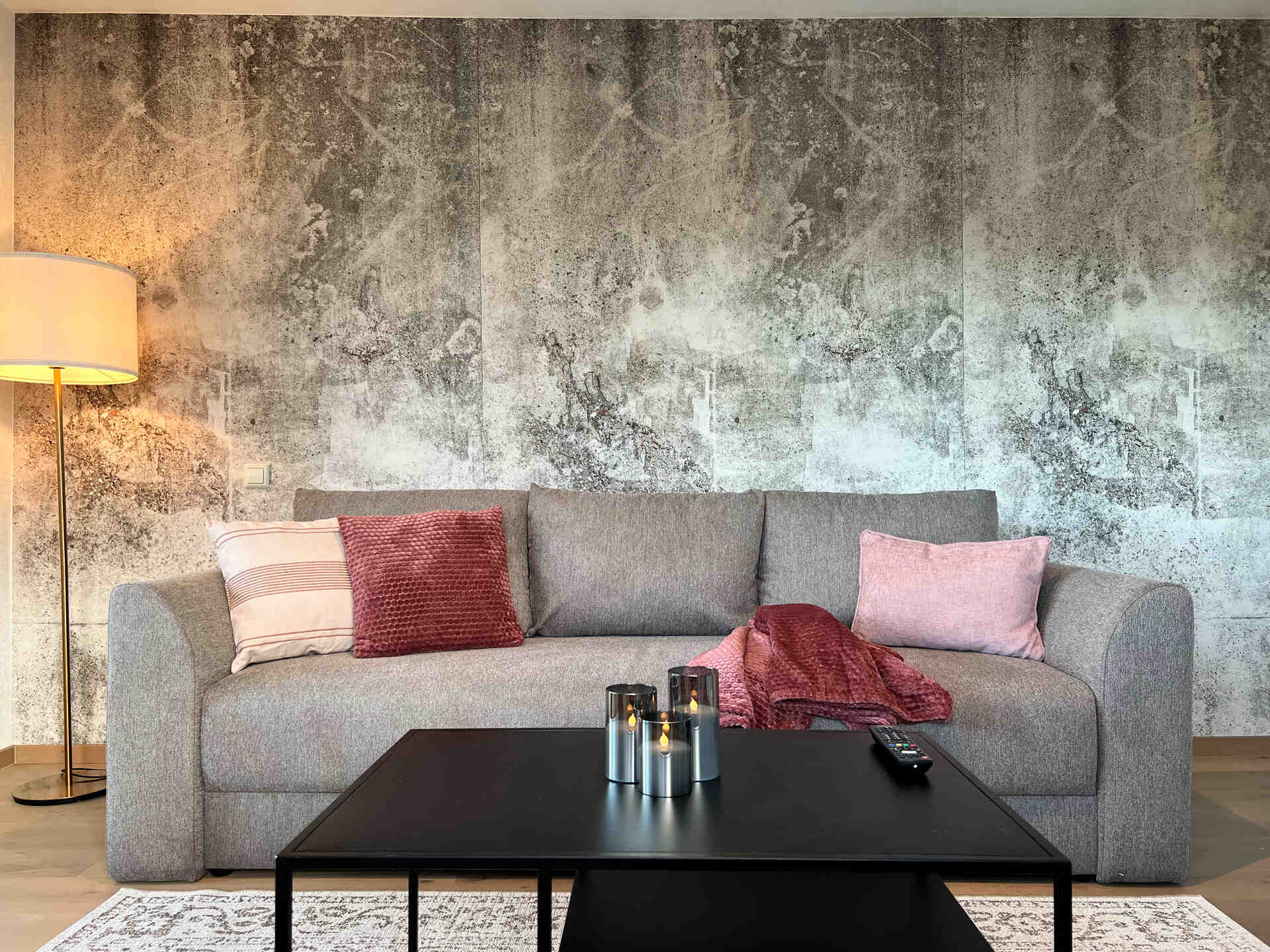 Wohnzimmer Boxspring Sofa mit Kissen vor stylischer Steintapete