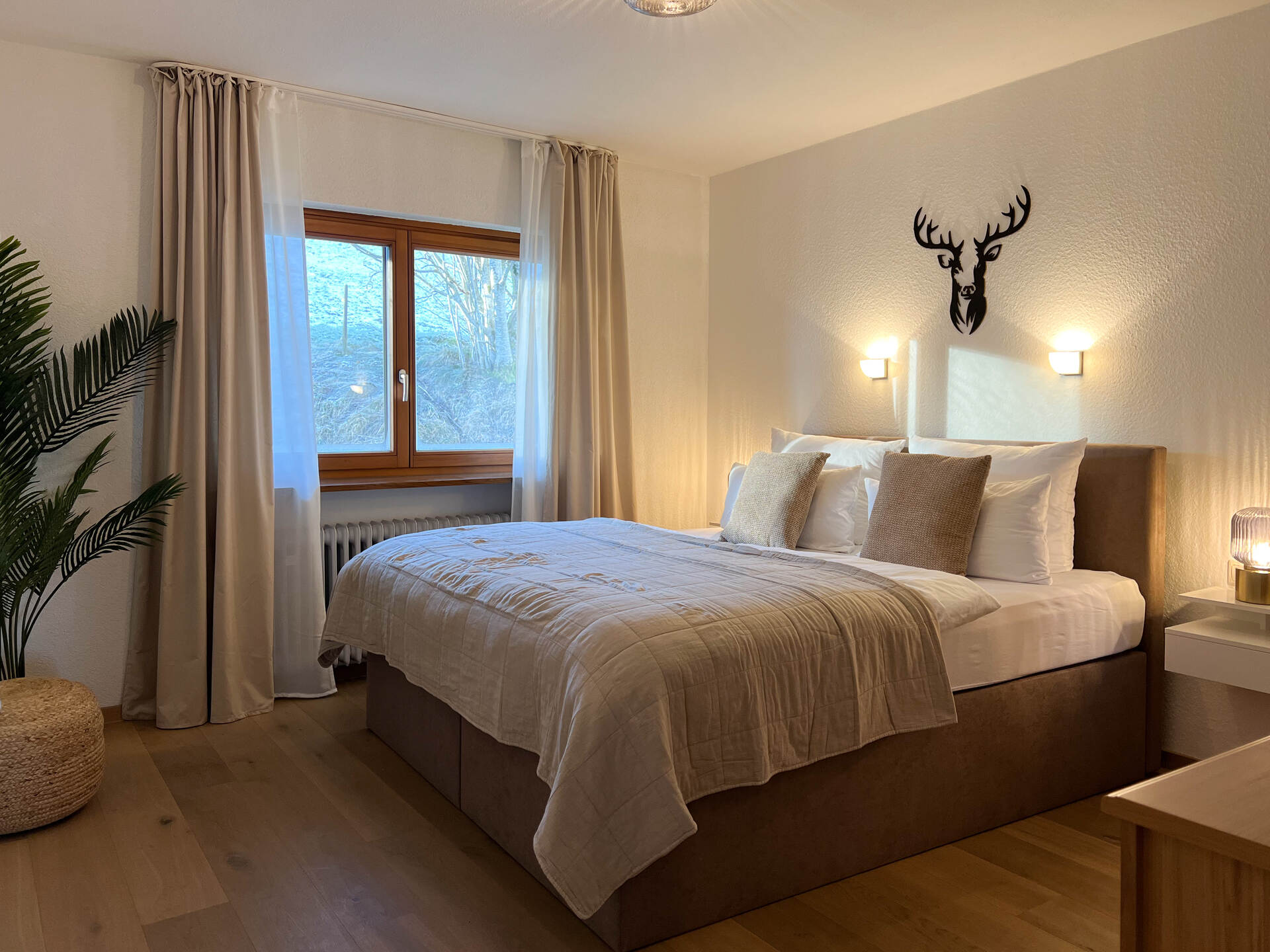 Schlafzimmer mit Doppelbett und Hirsch-Wanddeko