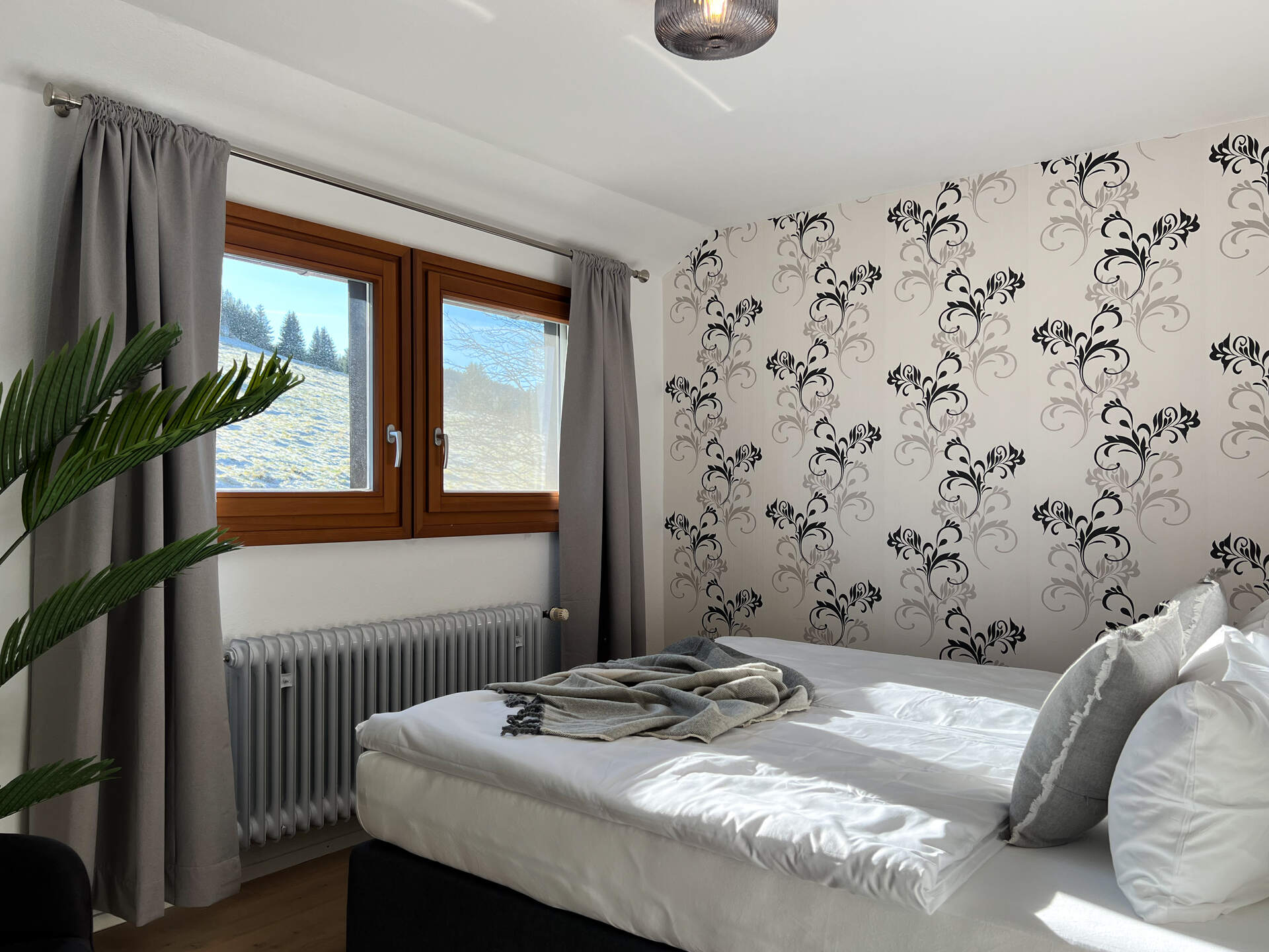 Schlafzimmer mit Ausblick auf verschneiten Hang