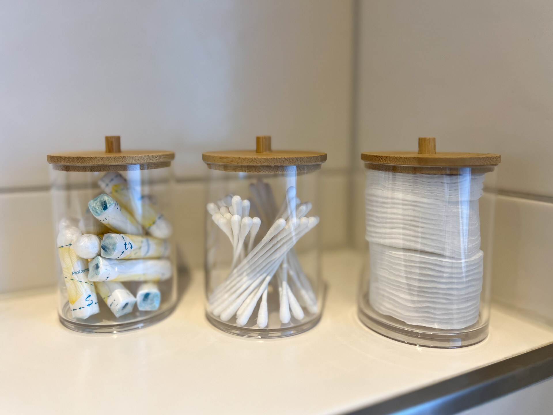 Badezimmerutensilien in Glaesern mit Holzdeckel