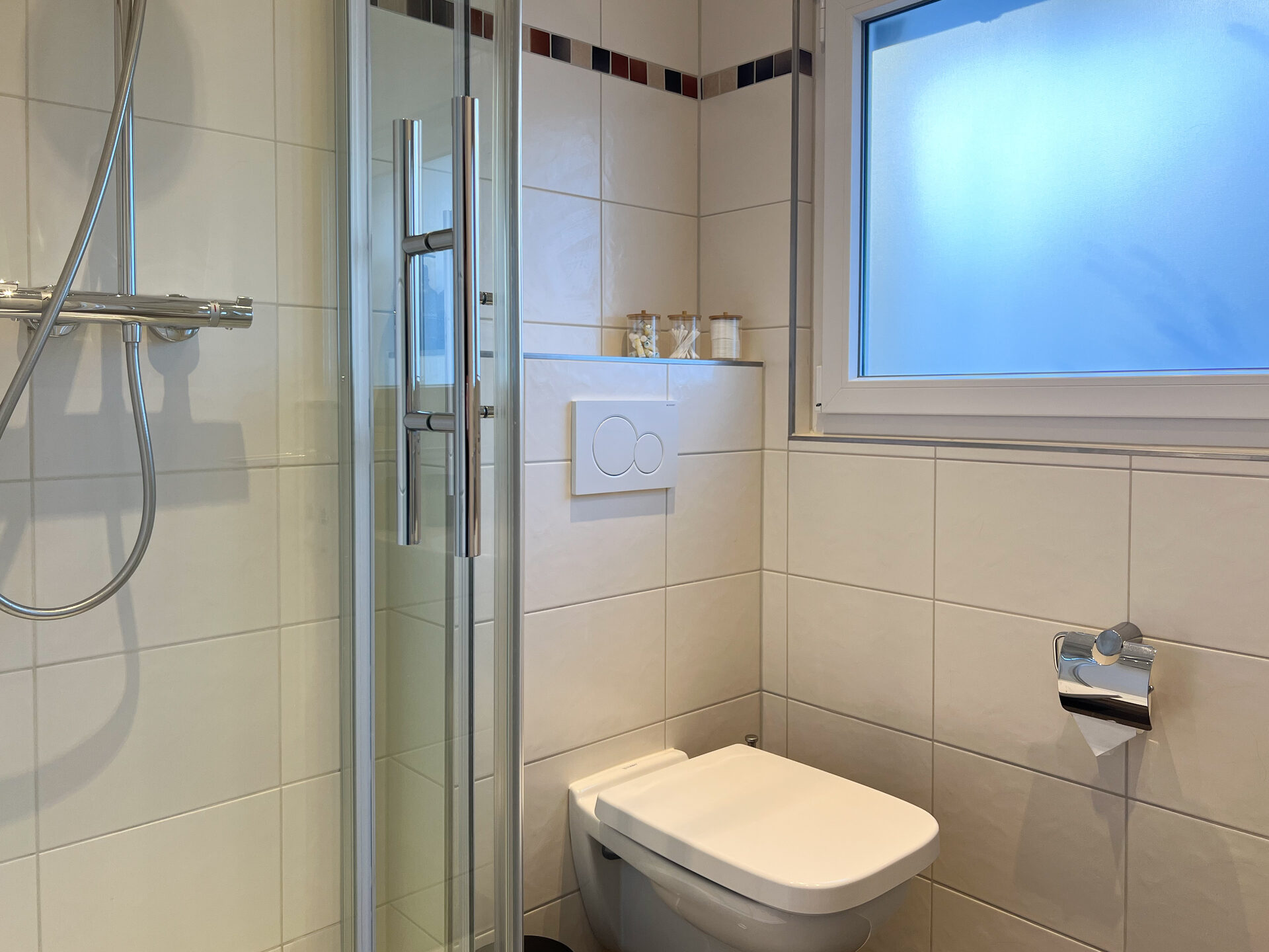 Badezimmer mit Toilette und Duschkabine