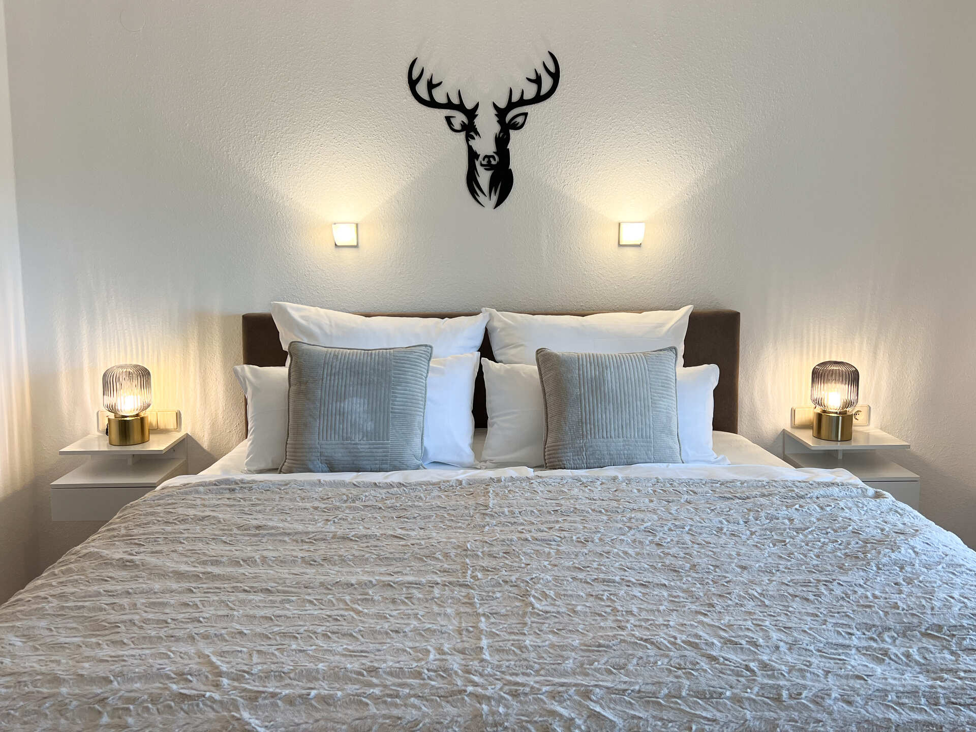 Doppelbett mit Kissen und Nachttischlampen