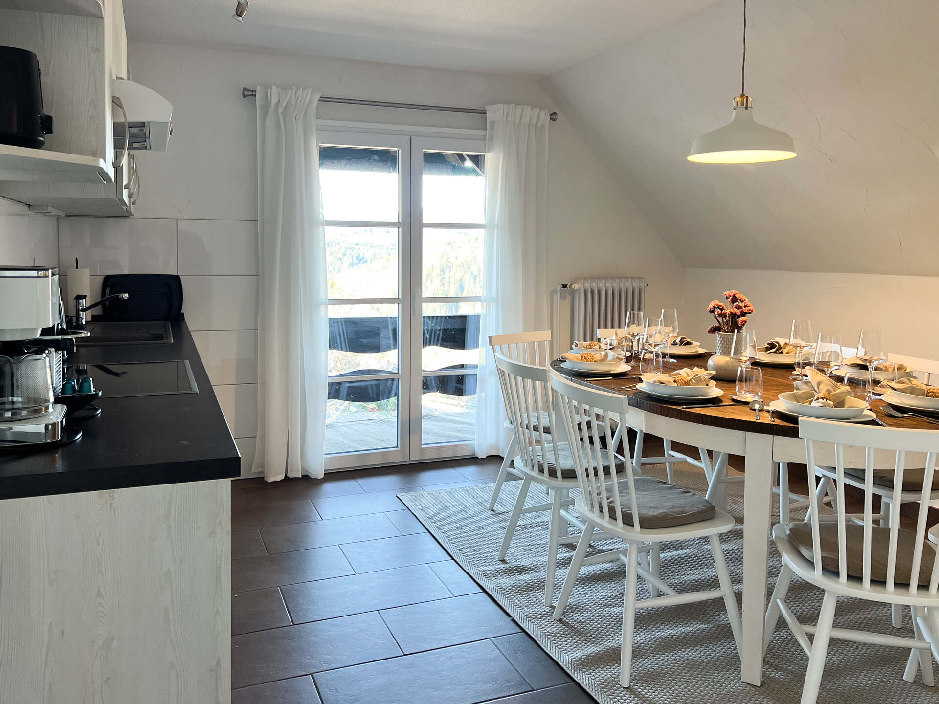Kueche mit grossem Esstisch und Fensterfront mit Blick auf den Feldberg