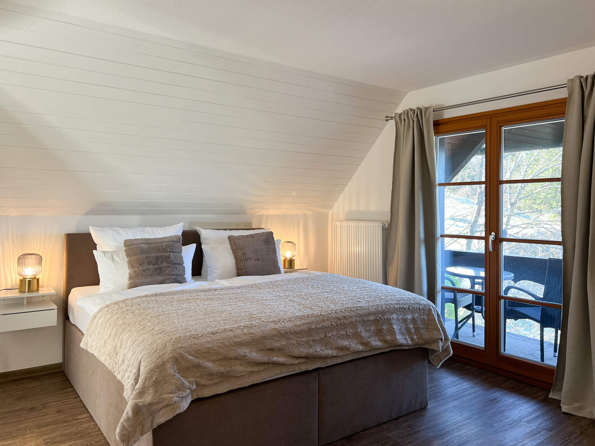Schlafzimmer mit Bett und Balkonzugang