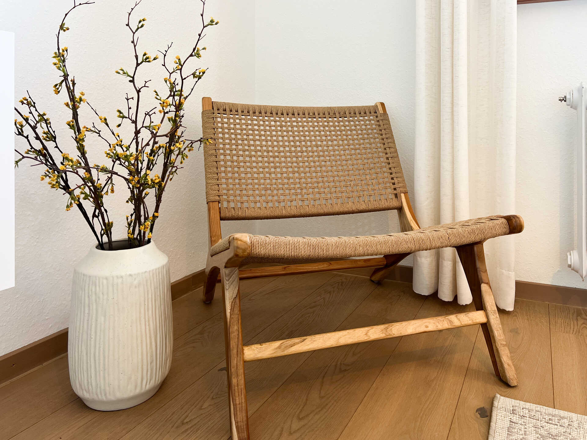 Holzstuhl mit Vase und Trockenblumen