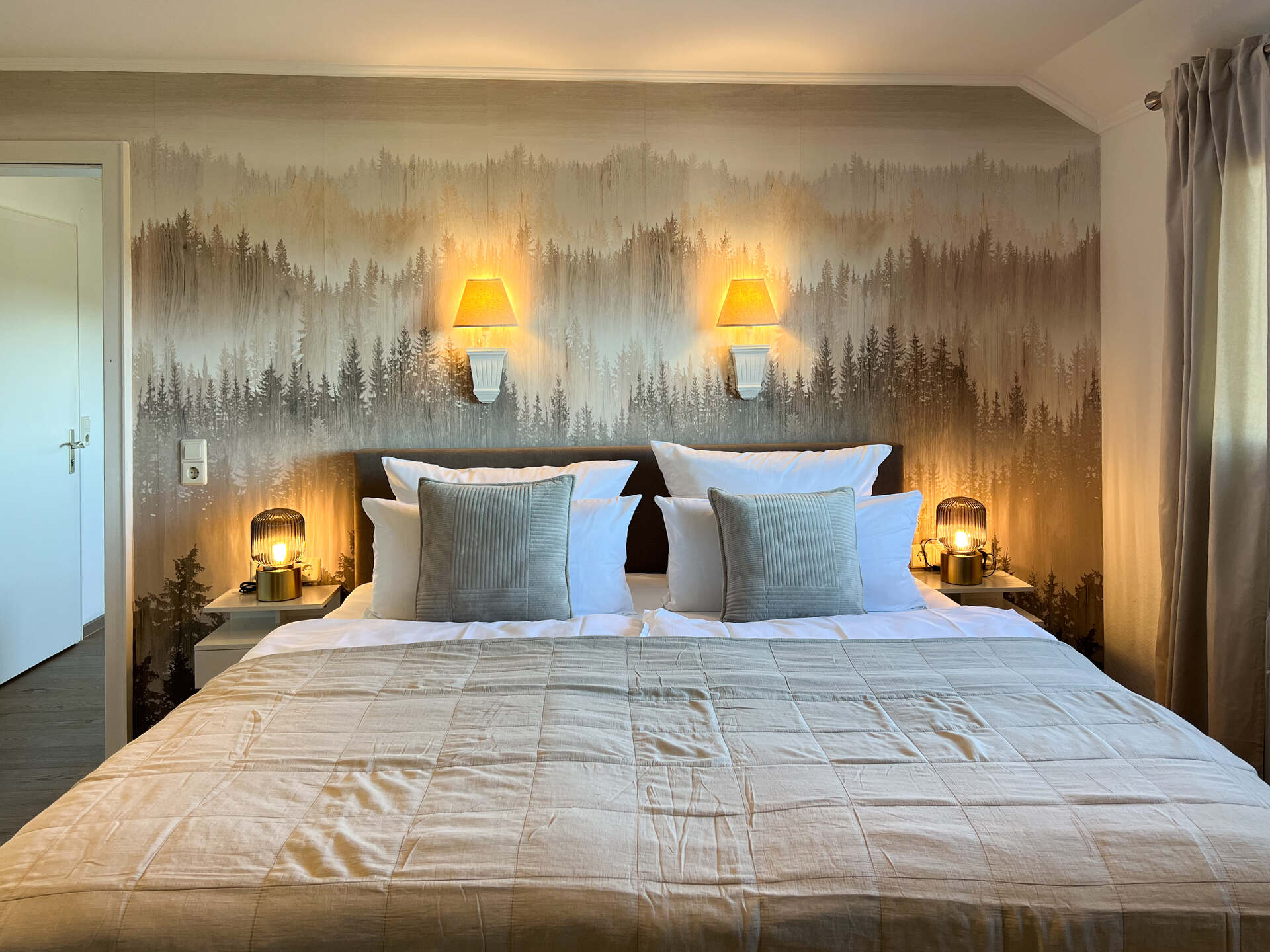 Doppelbett mit Waldbild und Wandlampen