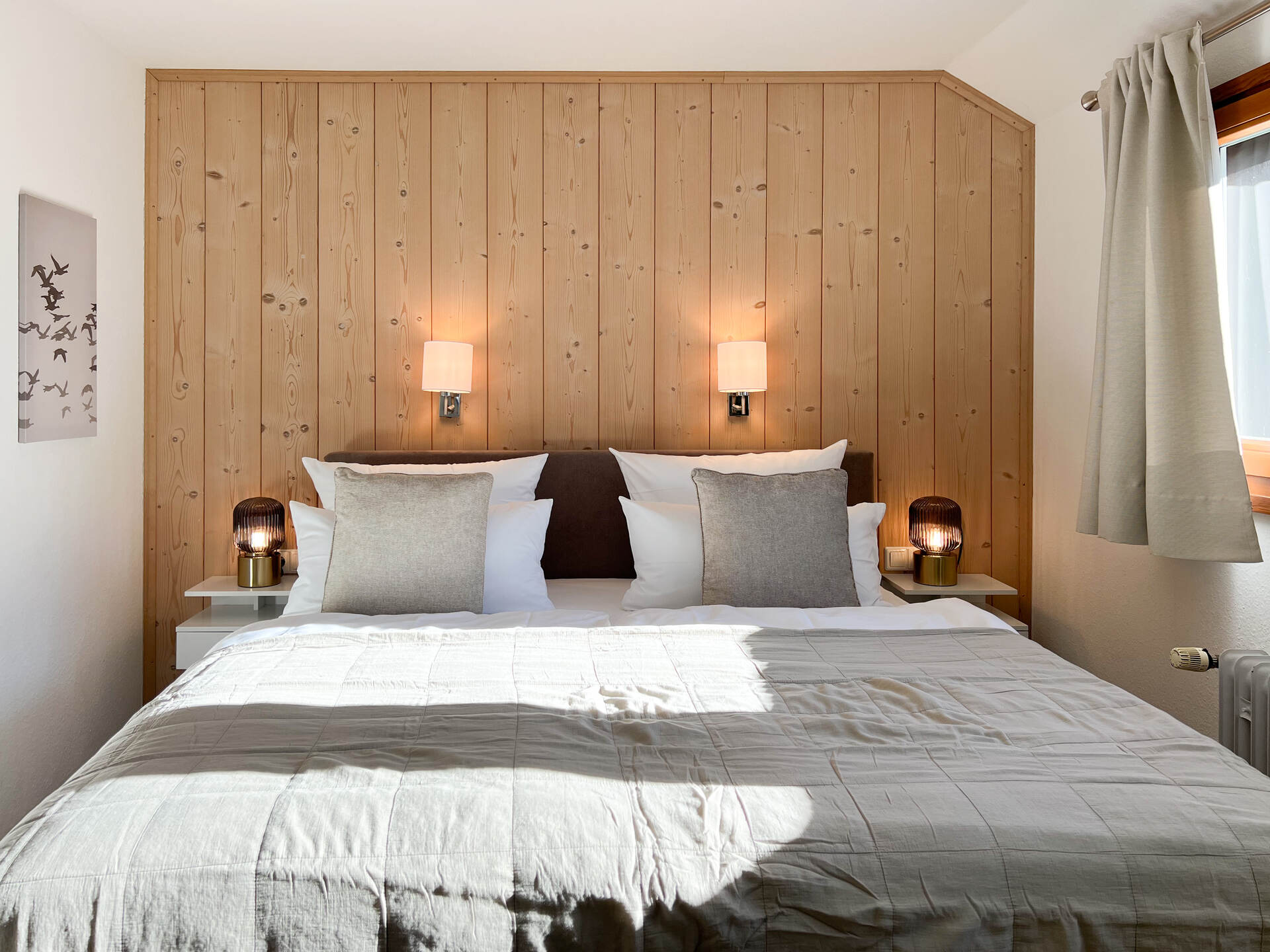 Doppelbett mit Holzrueckwand und Leselampen