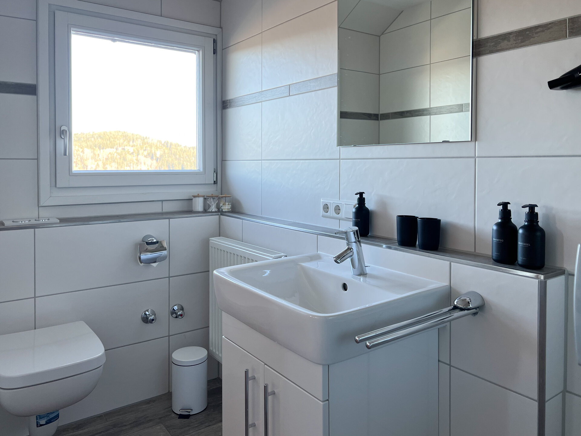 Waschbecken mit Spiegel und Spendern