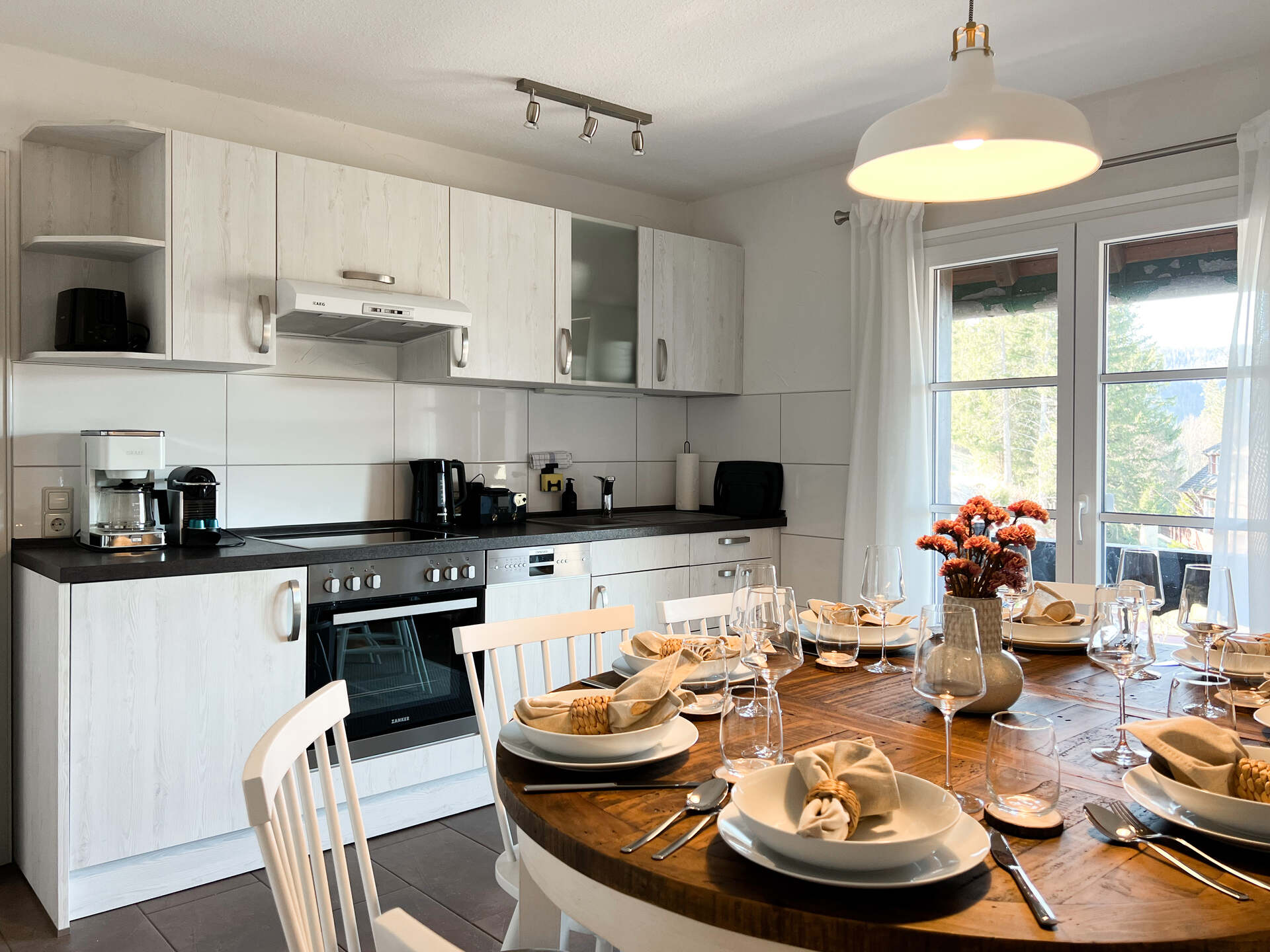 Kuechenzeile mit Geraeten und Esstisch