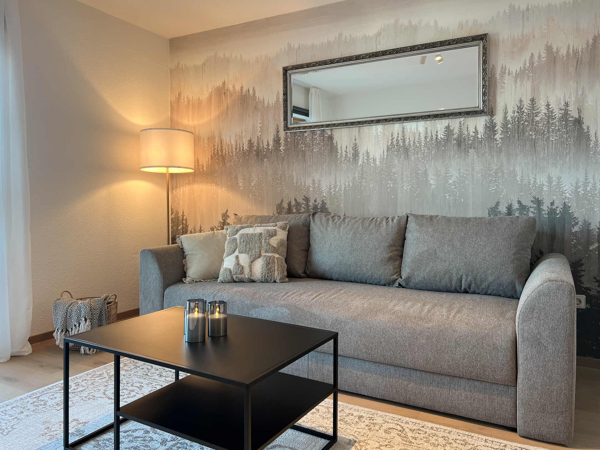 Sofa vor Waldtapete mit Stehlampe