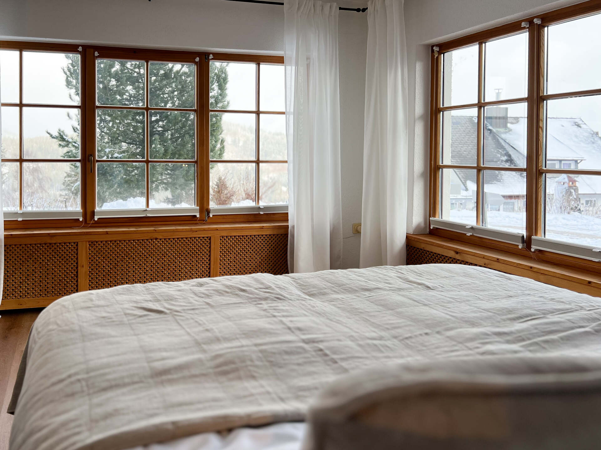 Blick aus dem Schlafzimmer auf verschneite Landschaft