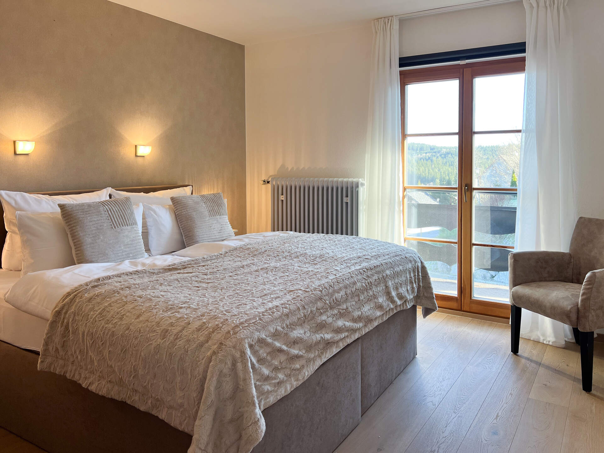 Schlafzimmer mit Doppelbett und Balkonblick