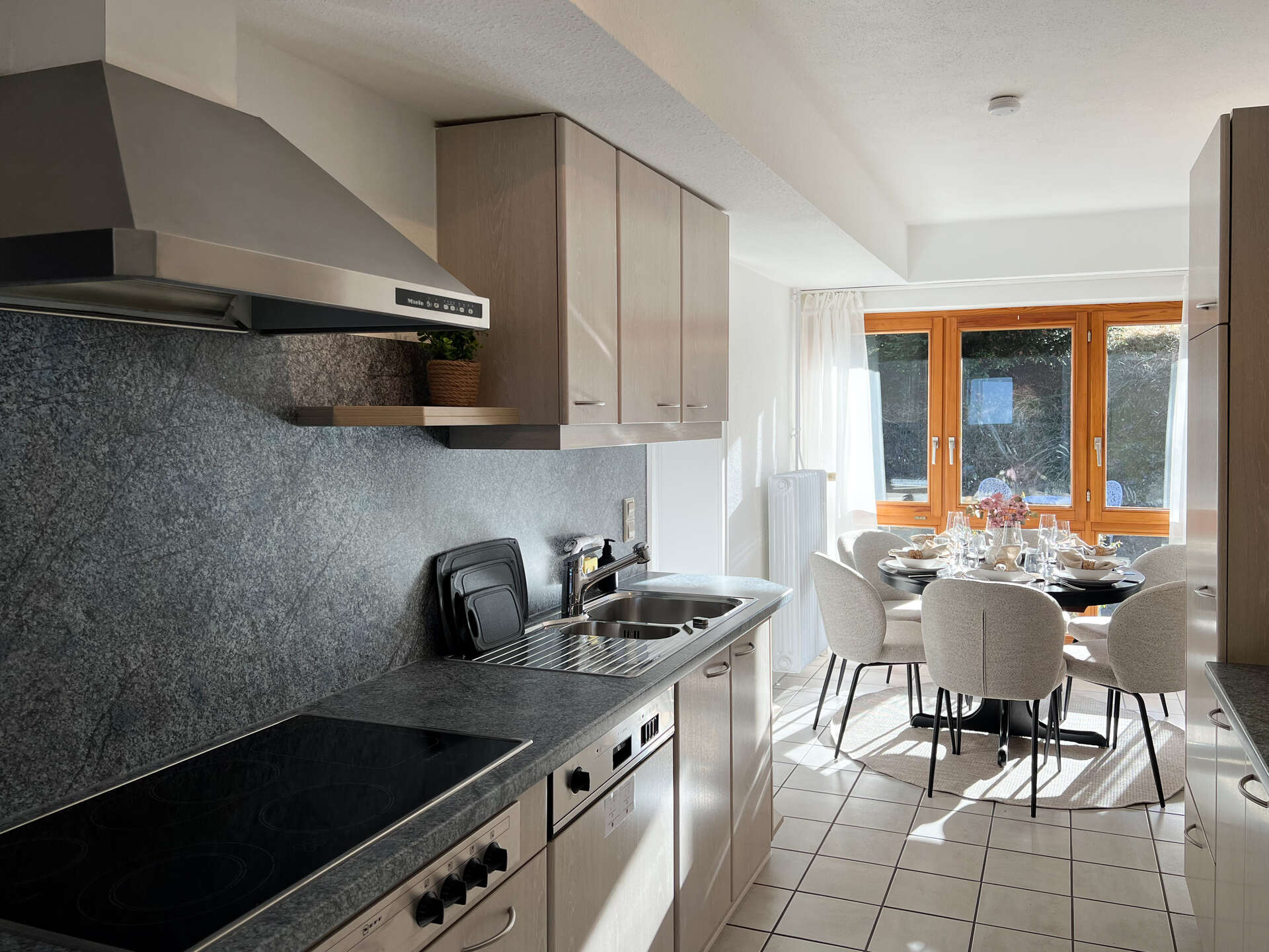 Kueche mit grauer Arbeitsplatte und Esstisch