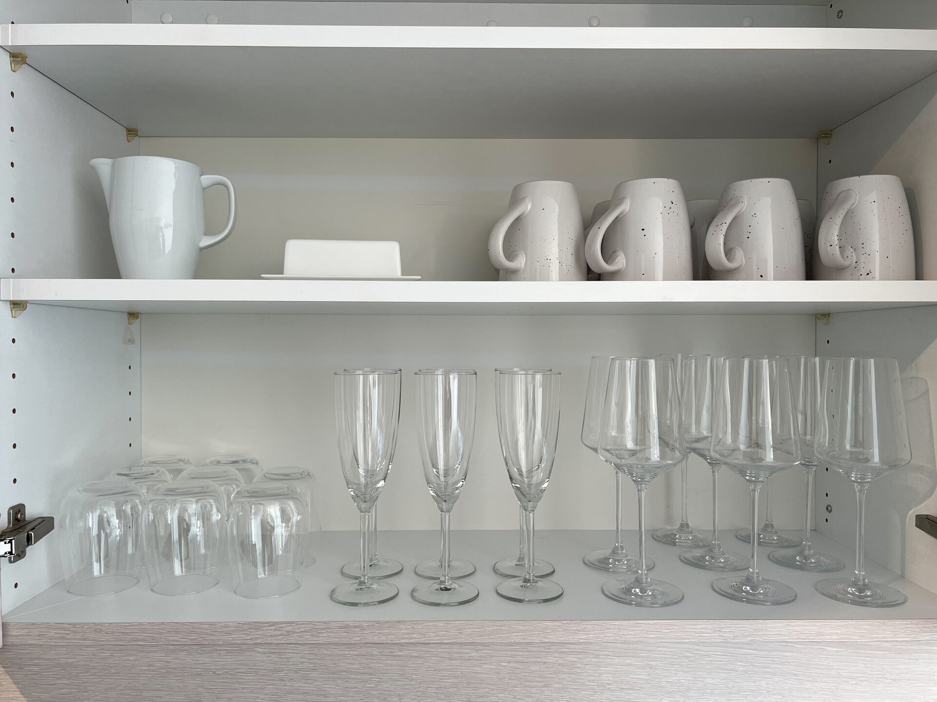 Kuechenschrank mit Glaesern, Tassen und Kanne