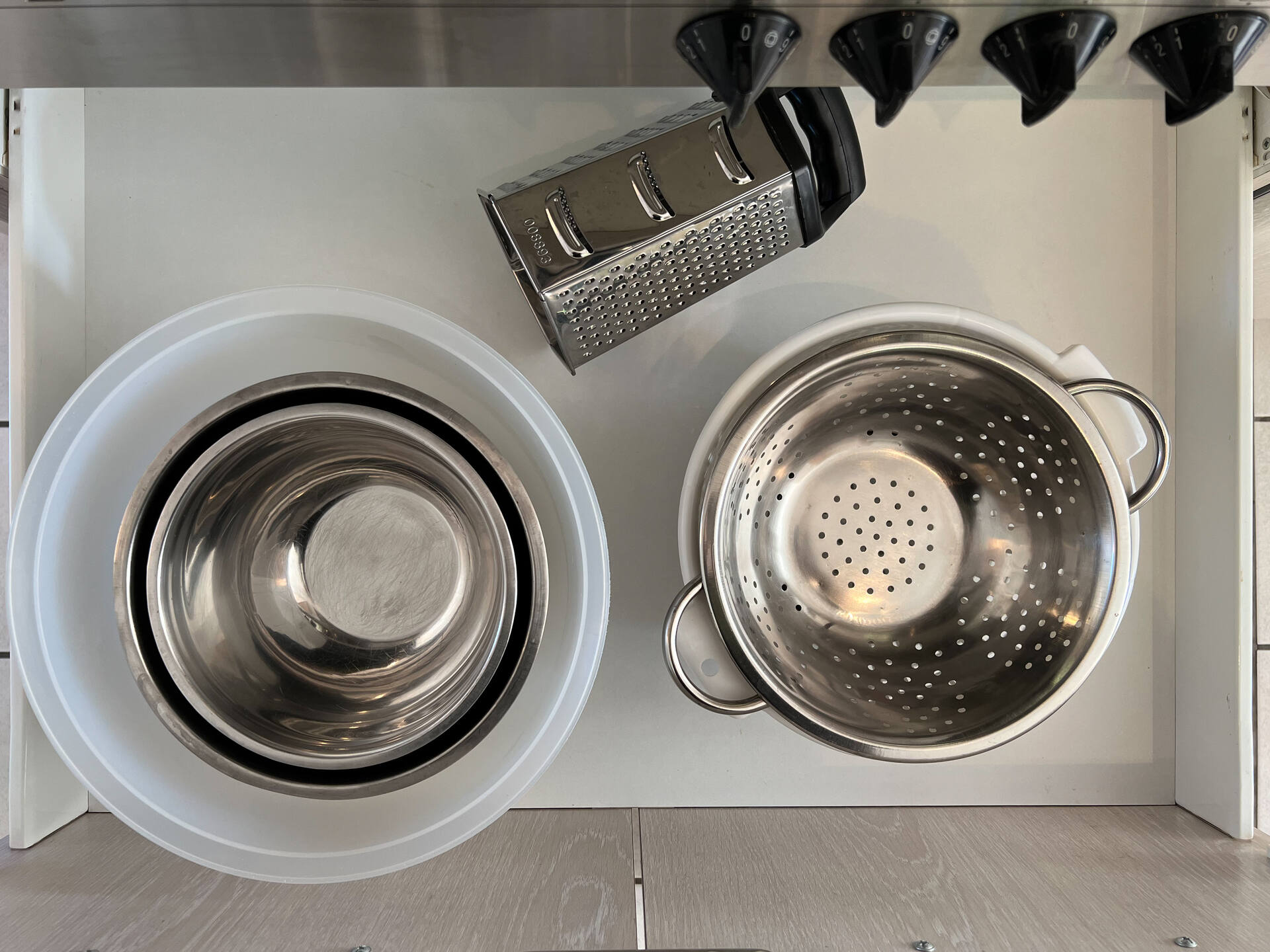 Kuechenschublade mit Schuesseln, Sieb und Reibe