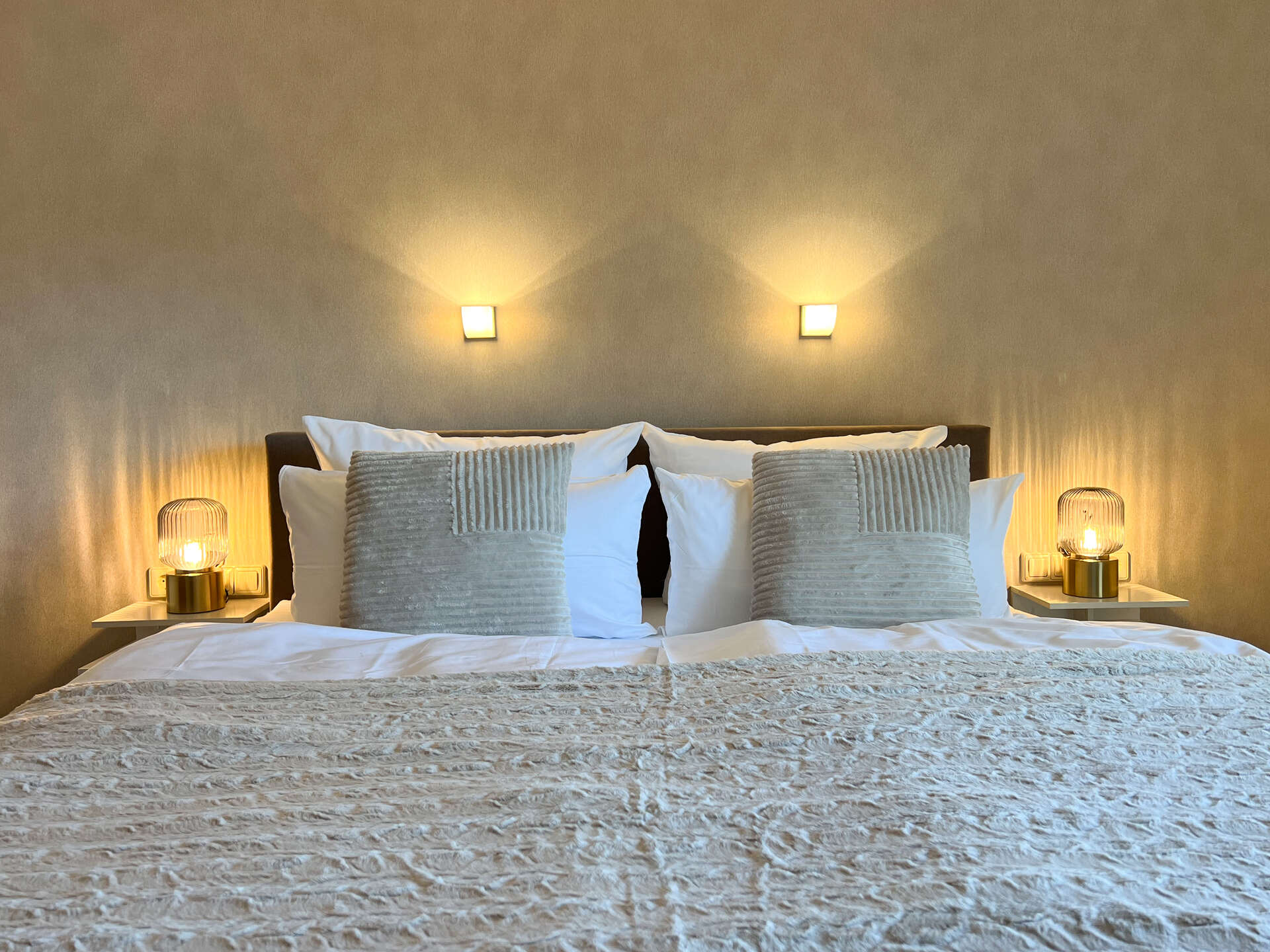 Doppelbett mit Nachttischlampen und Zierkissen