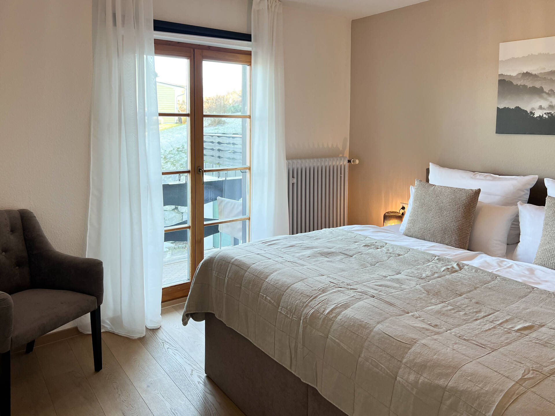 Schlafzimmer mit grossem Fenster und Vorhang