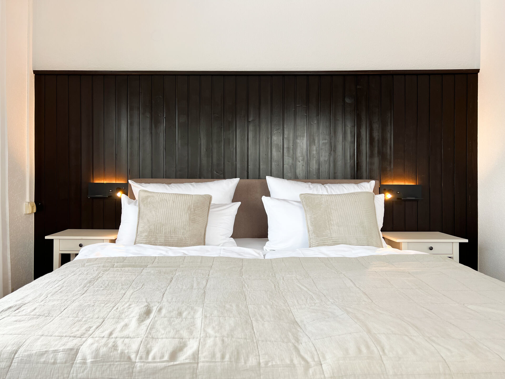 Doppelbett mit dunklem Holz-Kopfteil