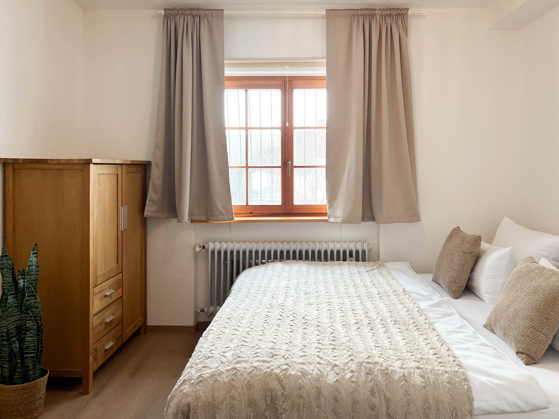 Schlafzimmer mit Fenster und weisser Bettwaesche