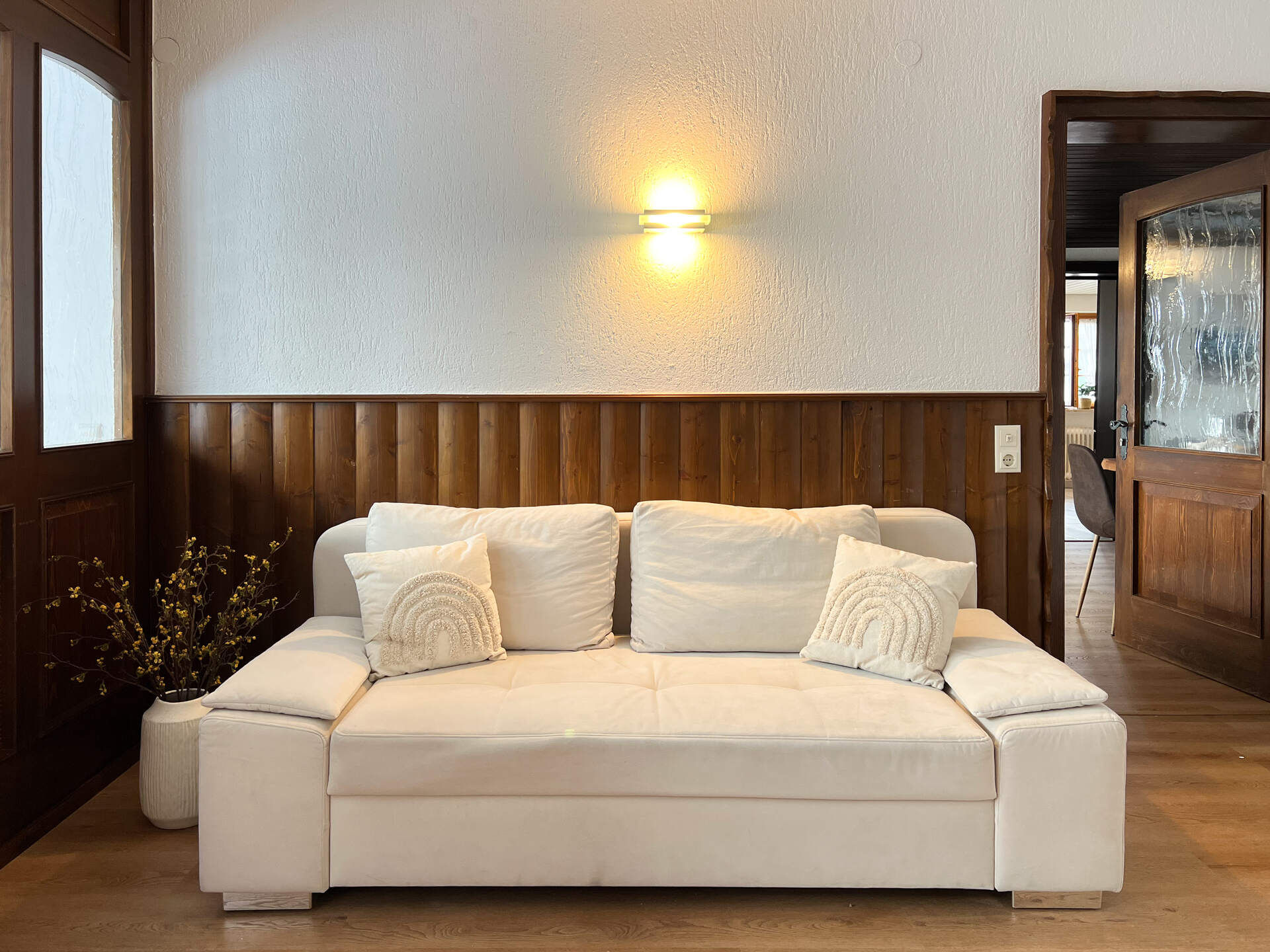 Helles Sofa im Eingangsbereich mit Holzverkleidung