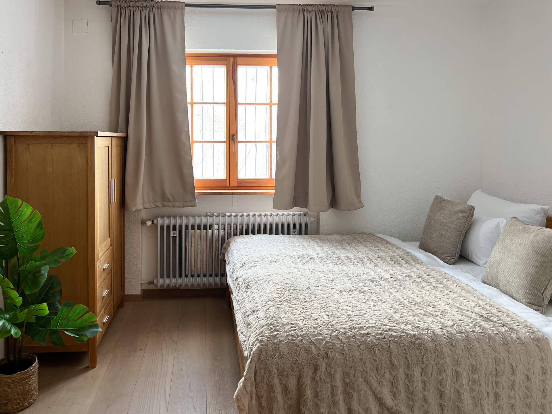 Schlafzimmer mit Holzschrank und Pflanzen