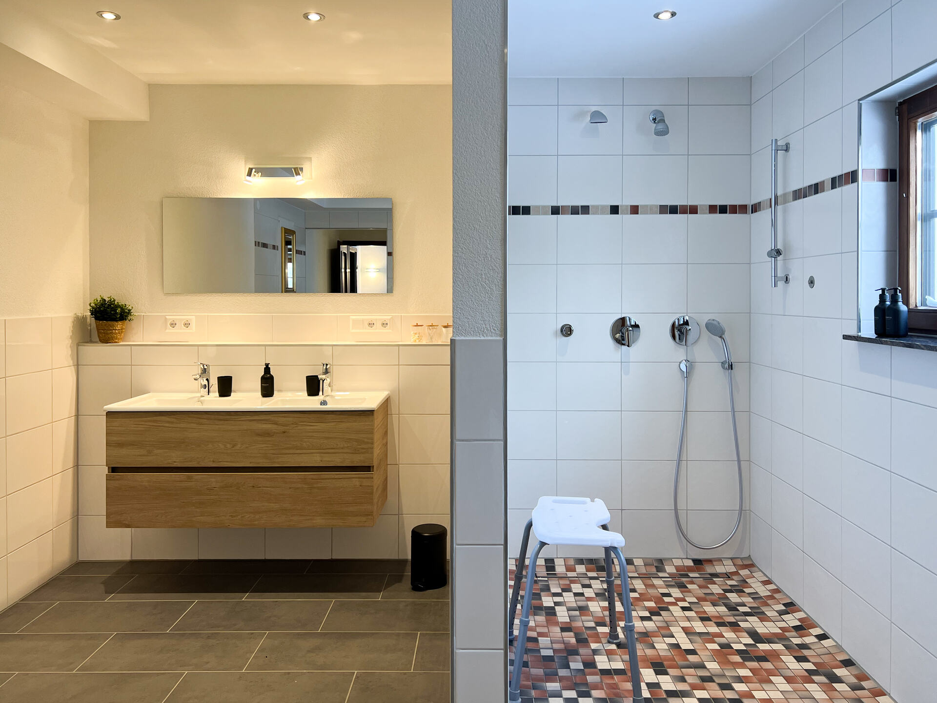 Ebenerdige, rollstuhlgerechte Dusche mit Hocker und Fliesenboden