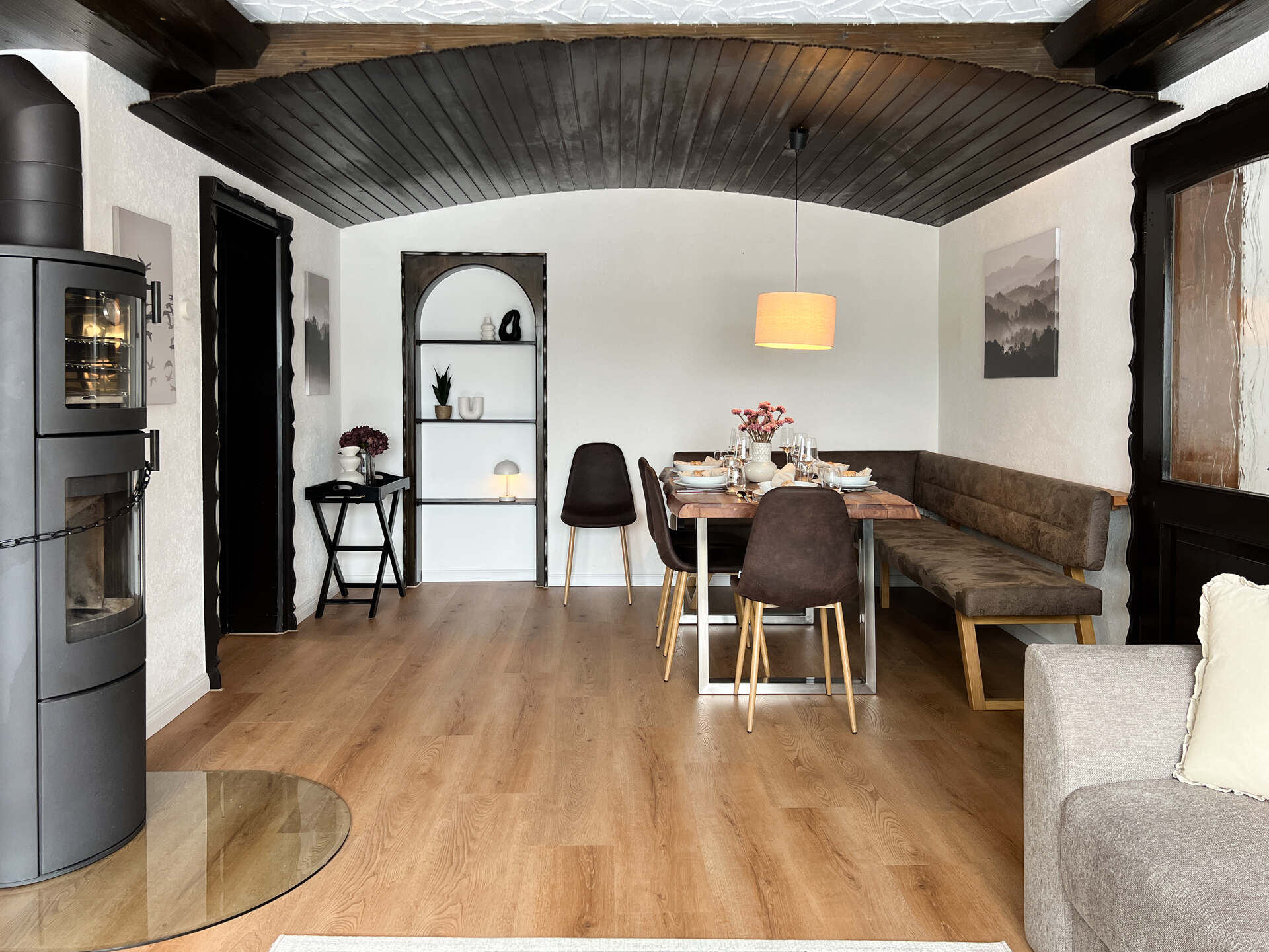 Wohnzimmer mit Sofa, Ofen und Holzboden