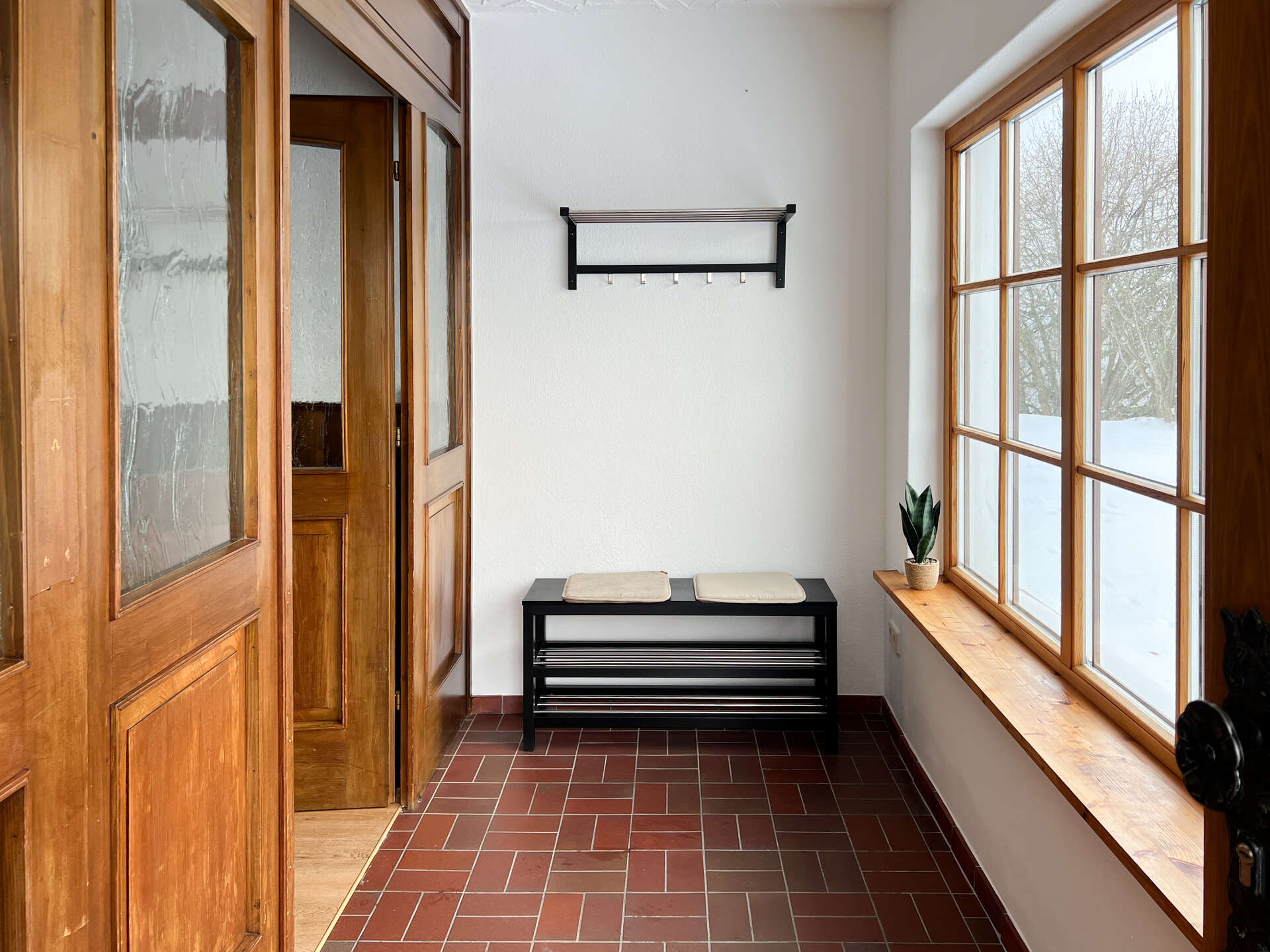 Garderobe mit Sitzbank und Fensterfront