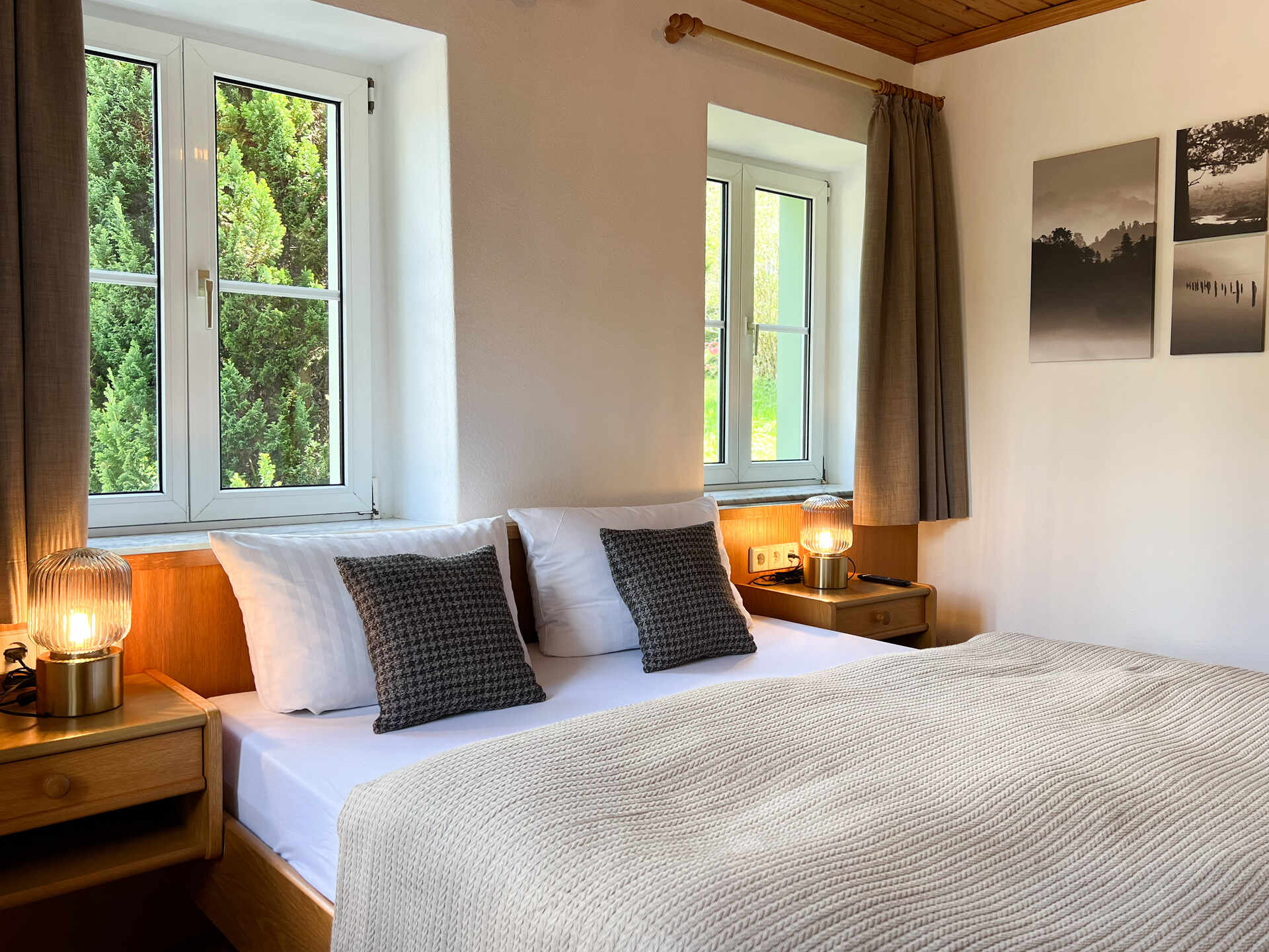 Gemuetliches Bett mit Kissen und Wandbildern