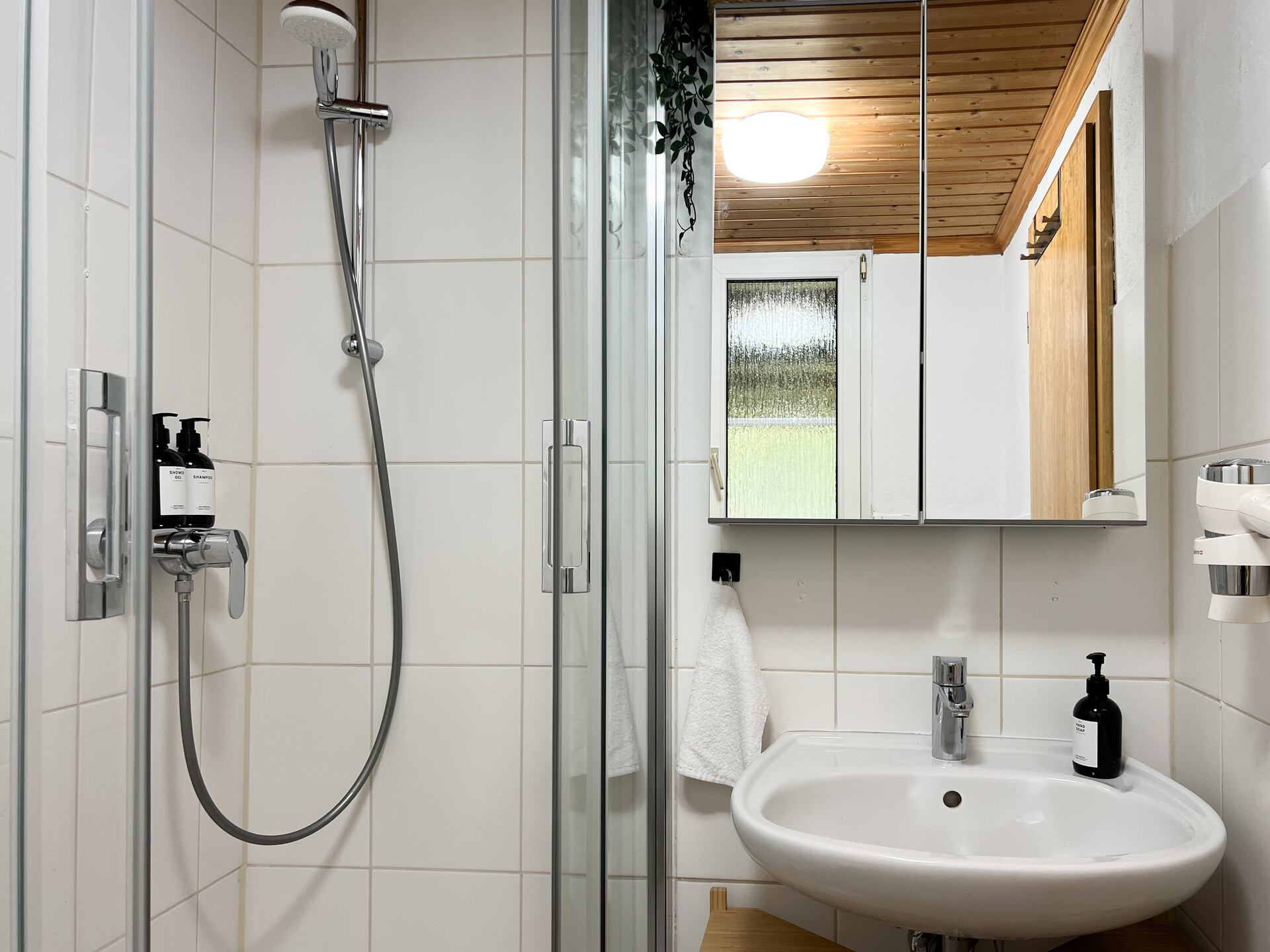 Modernes Badezimmer mit Dusche, Waschbecken und Spiegel-Schrank