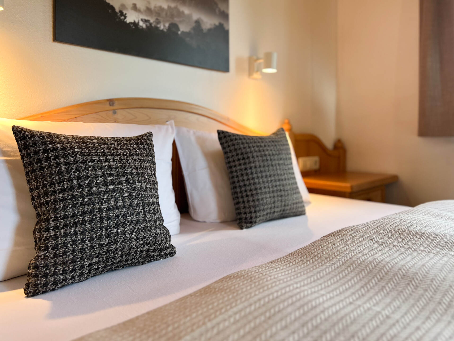 Doppelbett mit Holzkopfteil und Zierkissen