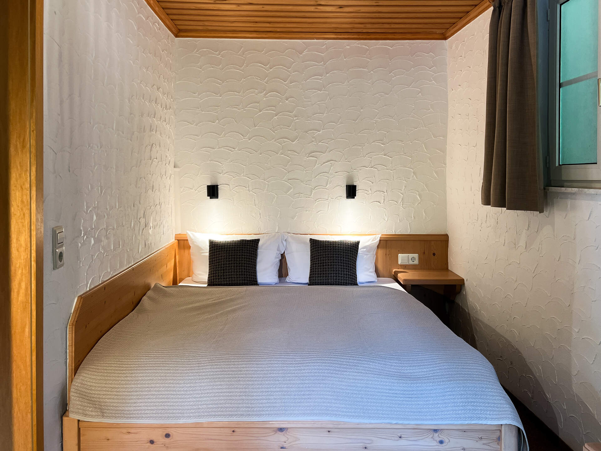 Gemuetliches Doppelbett mit Holzverkleidung