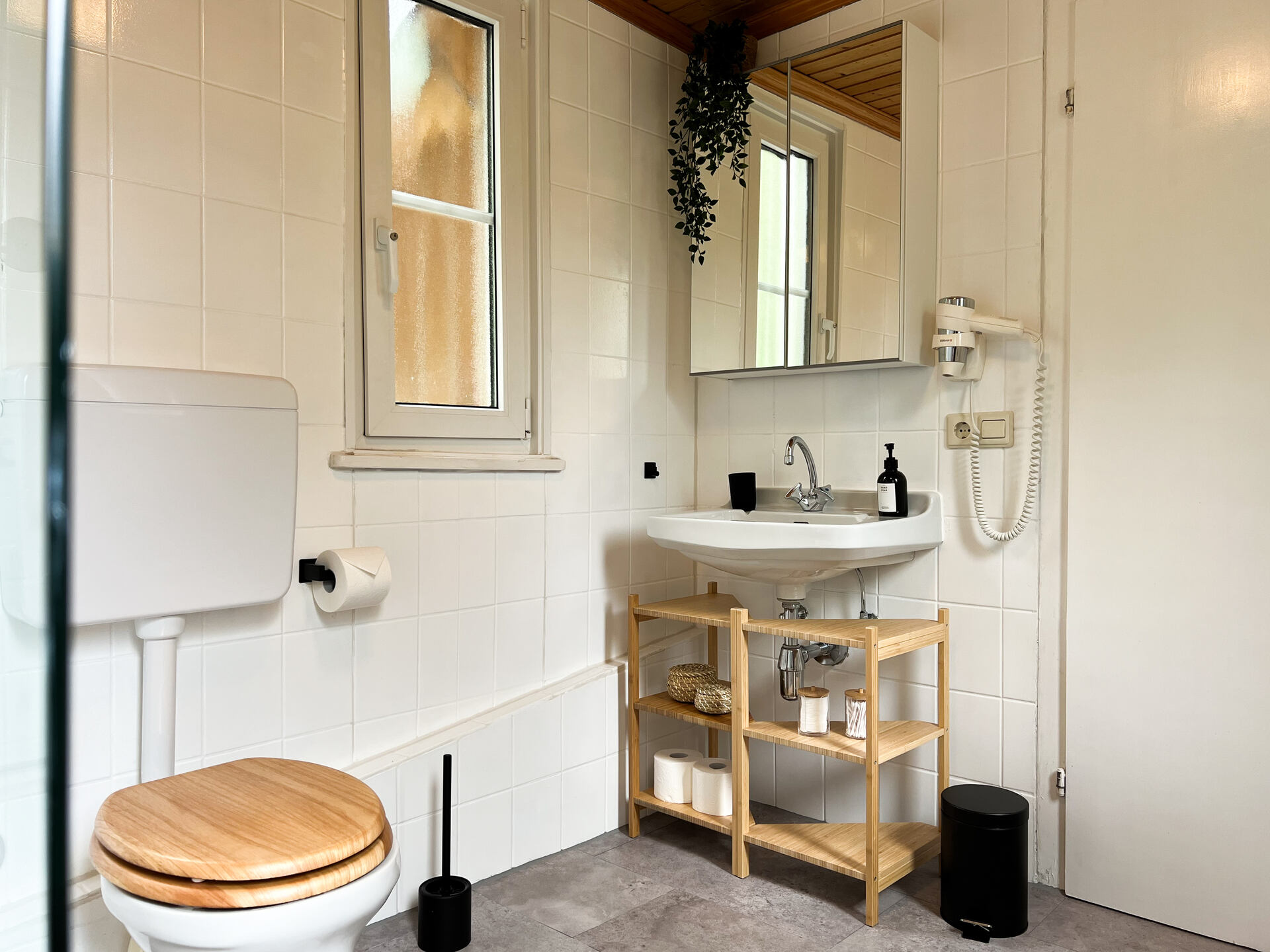 Waschbecken mit Spiegel und Holzregal