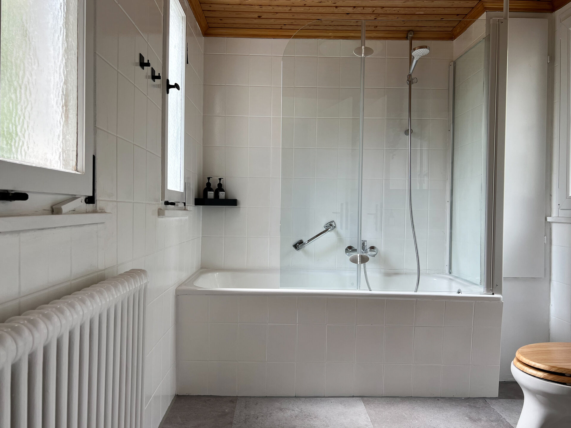 Badezimmer mit Badewanne und Duschwand