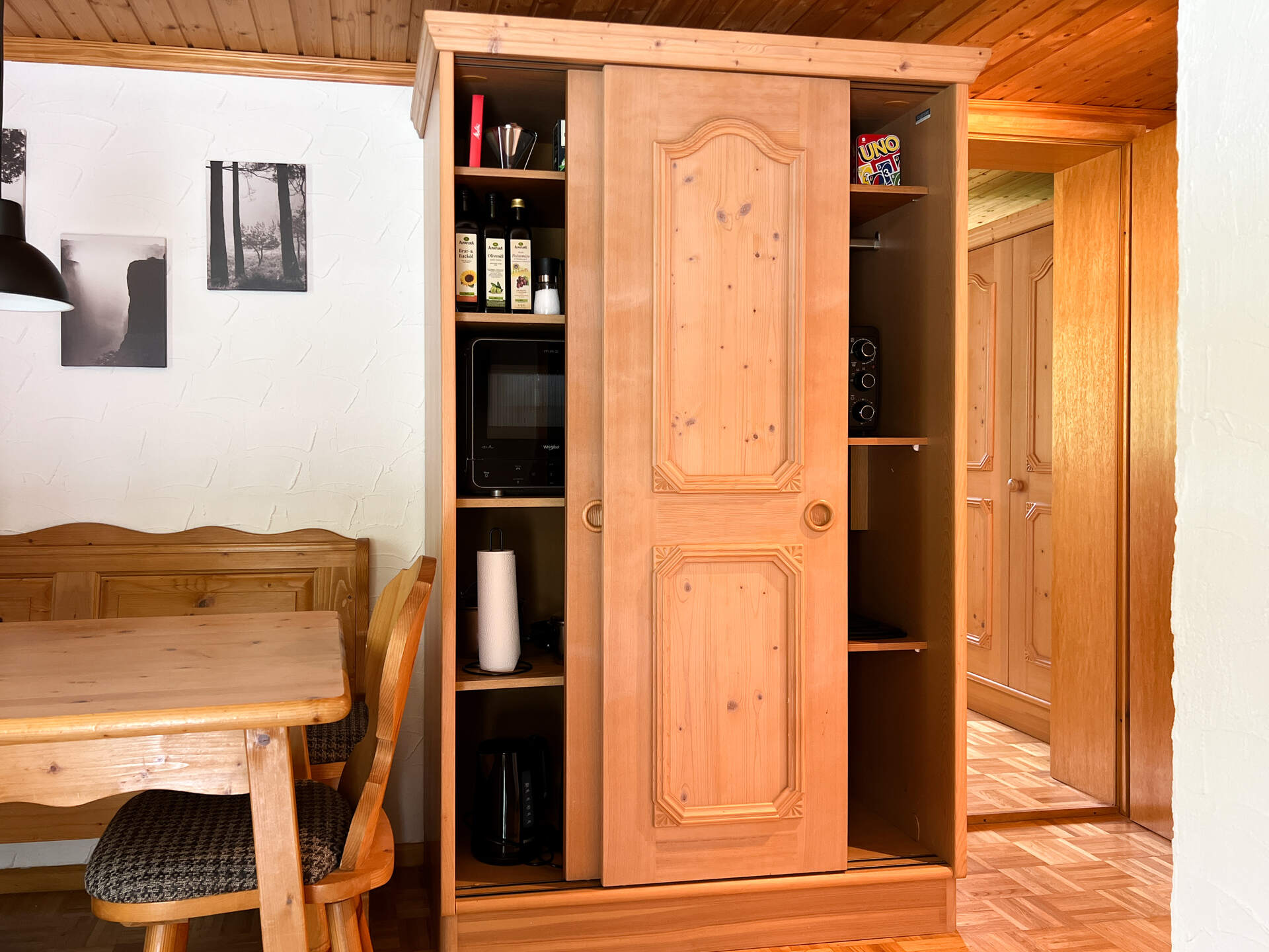 Offener Kuechenschrank mit Mikrowelle und Kuechenhelfern