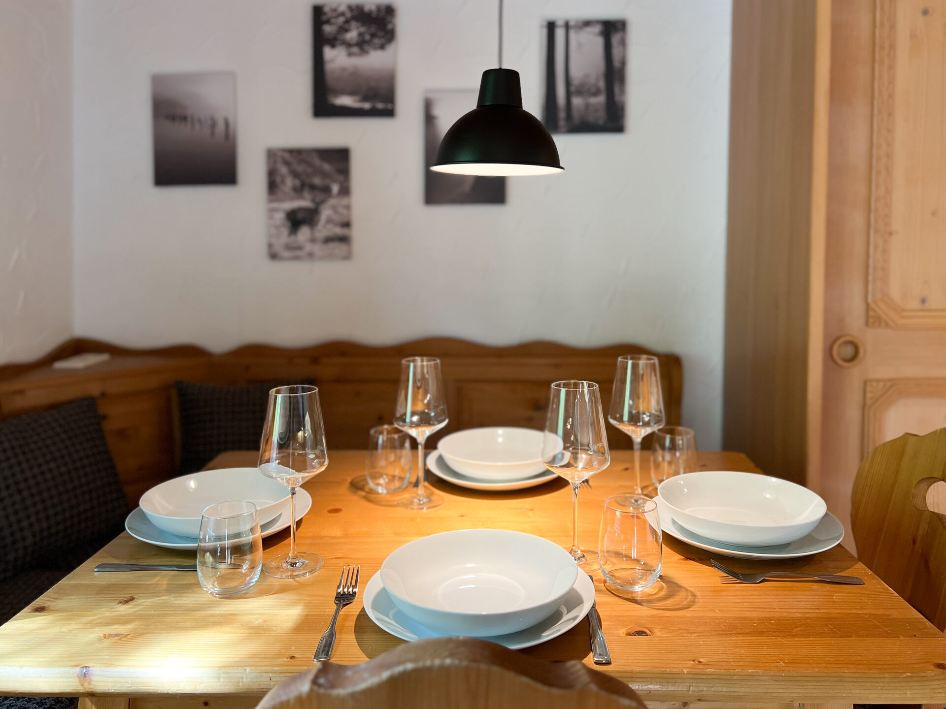 Esstisch mit gedecktem Geschirr und gemuetlicher Eckbank