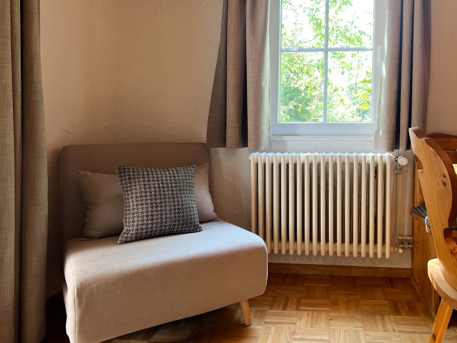 Gemuetliche Sitzecke mit Sessel und Blick aus dem Fenster