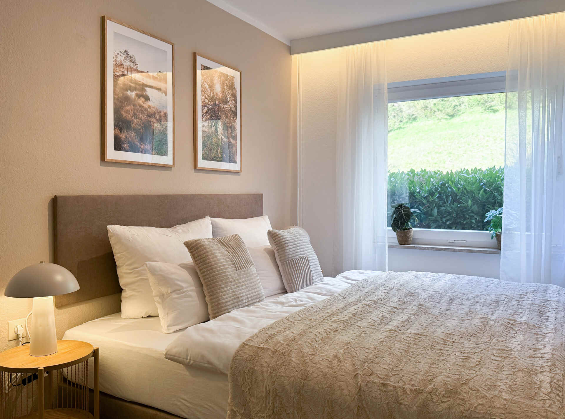 Doppelbett mit Spiegel und Fernseher an Wand