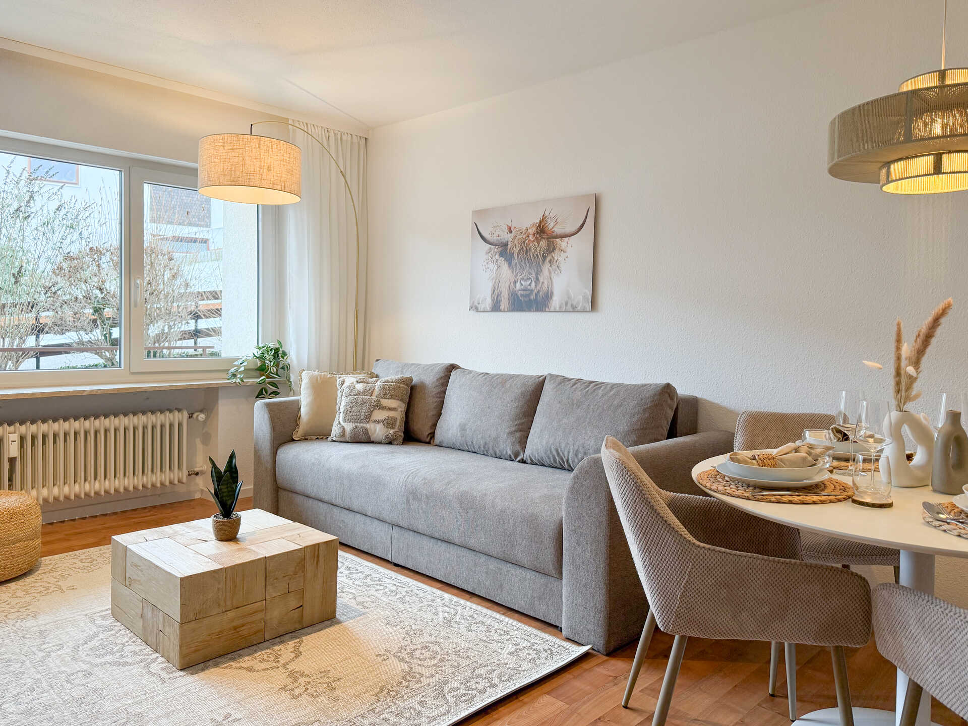 Wohnzimmer mit grauem Sofa und Holztisch