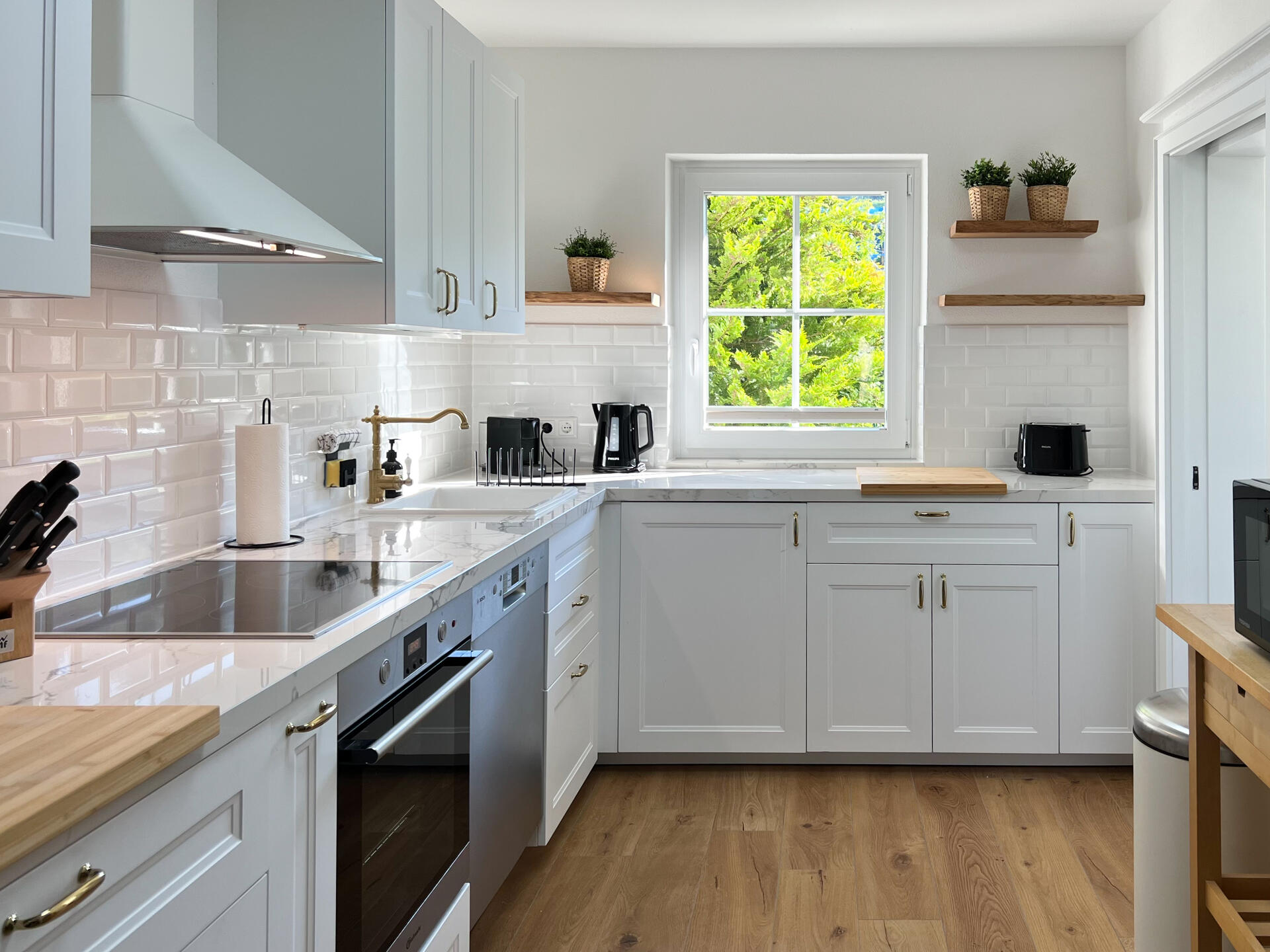 Moderne Kueche mit weissen Fronten und Holzdetails