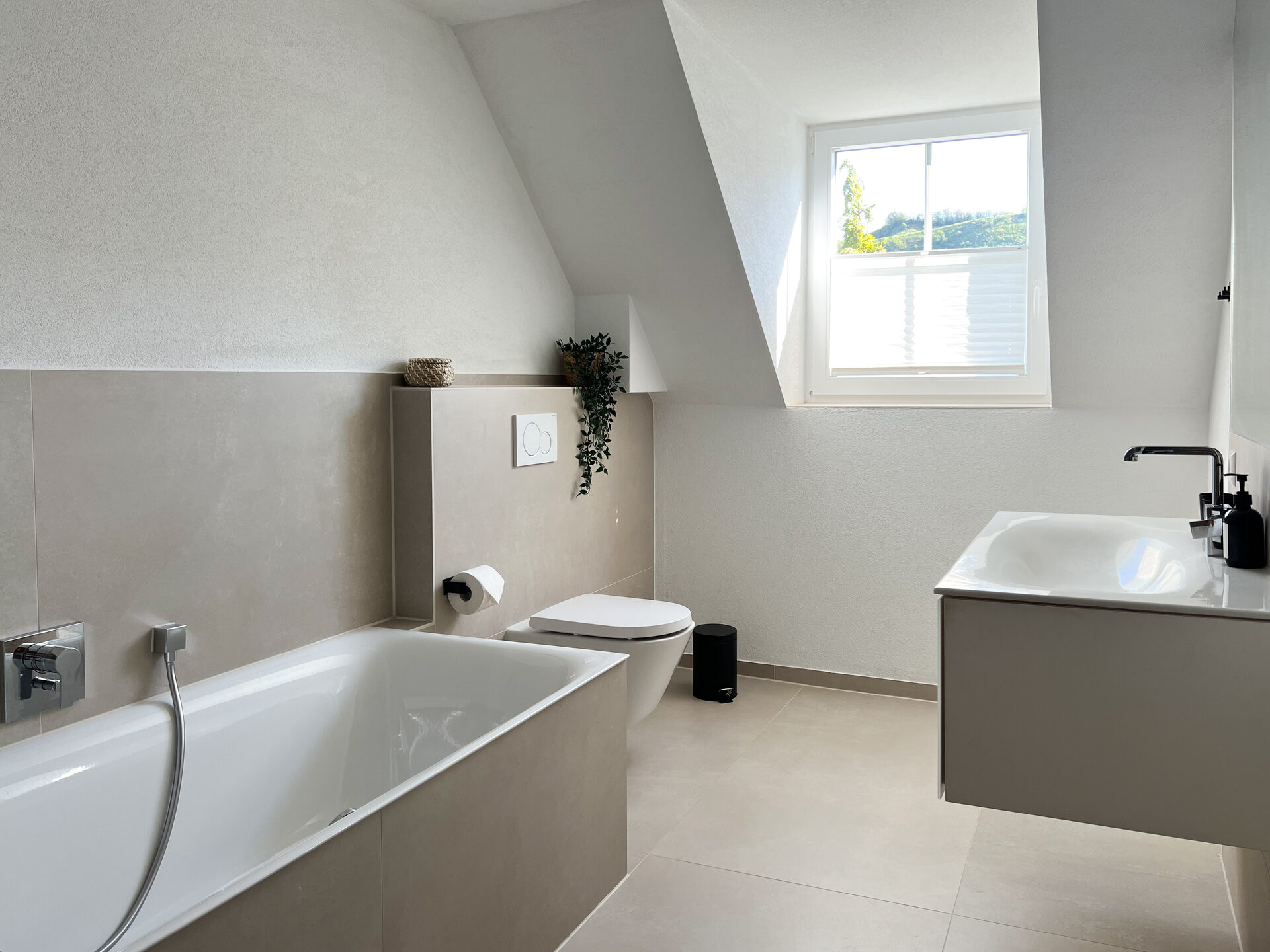 Helles Badezimmer mit Badewanne und Fenster