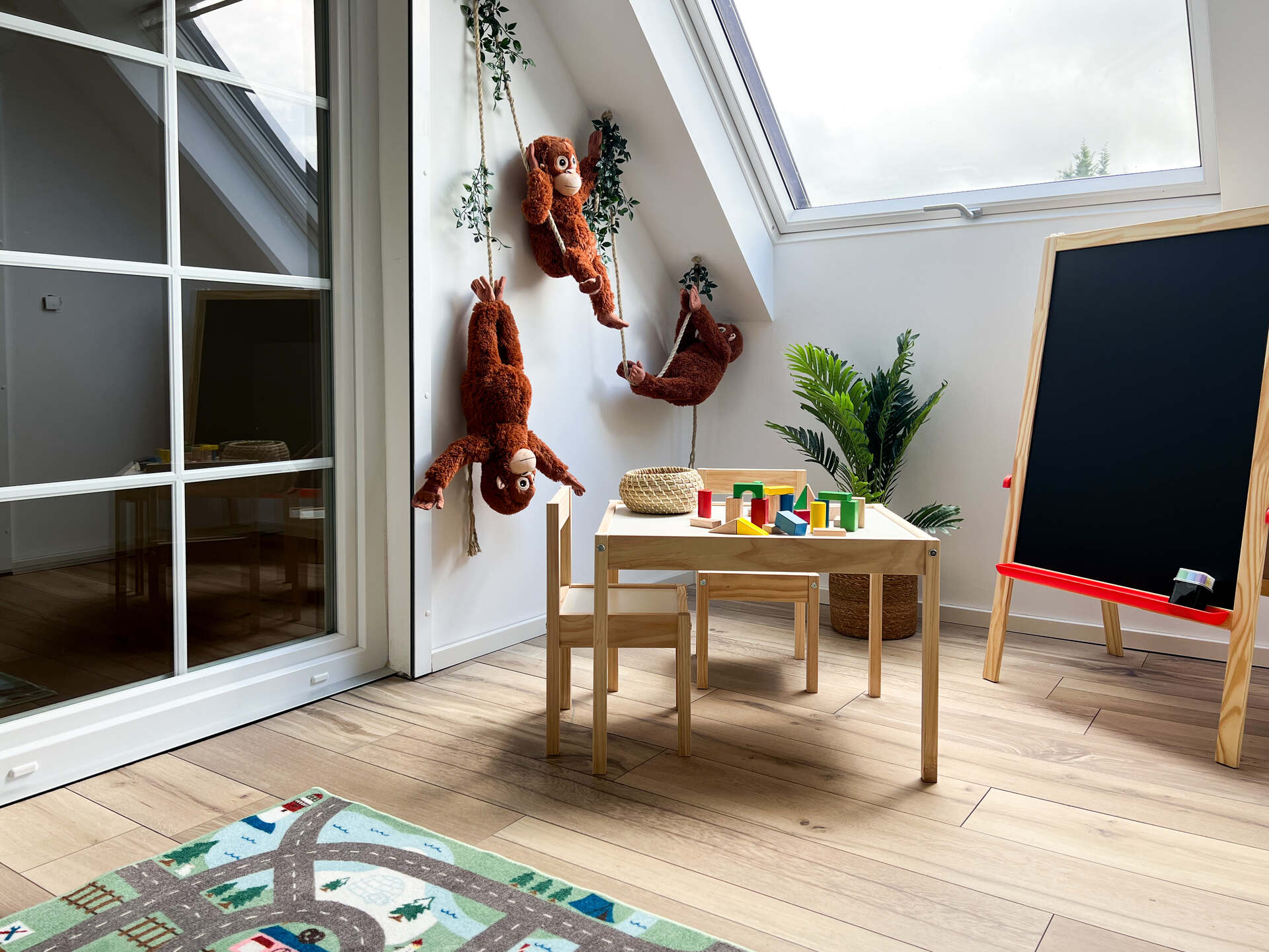 Spielezimmer mit Haengemarke, Tisch und Tafel