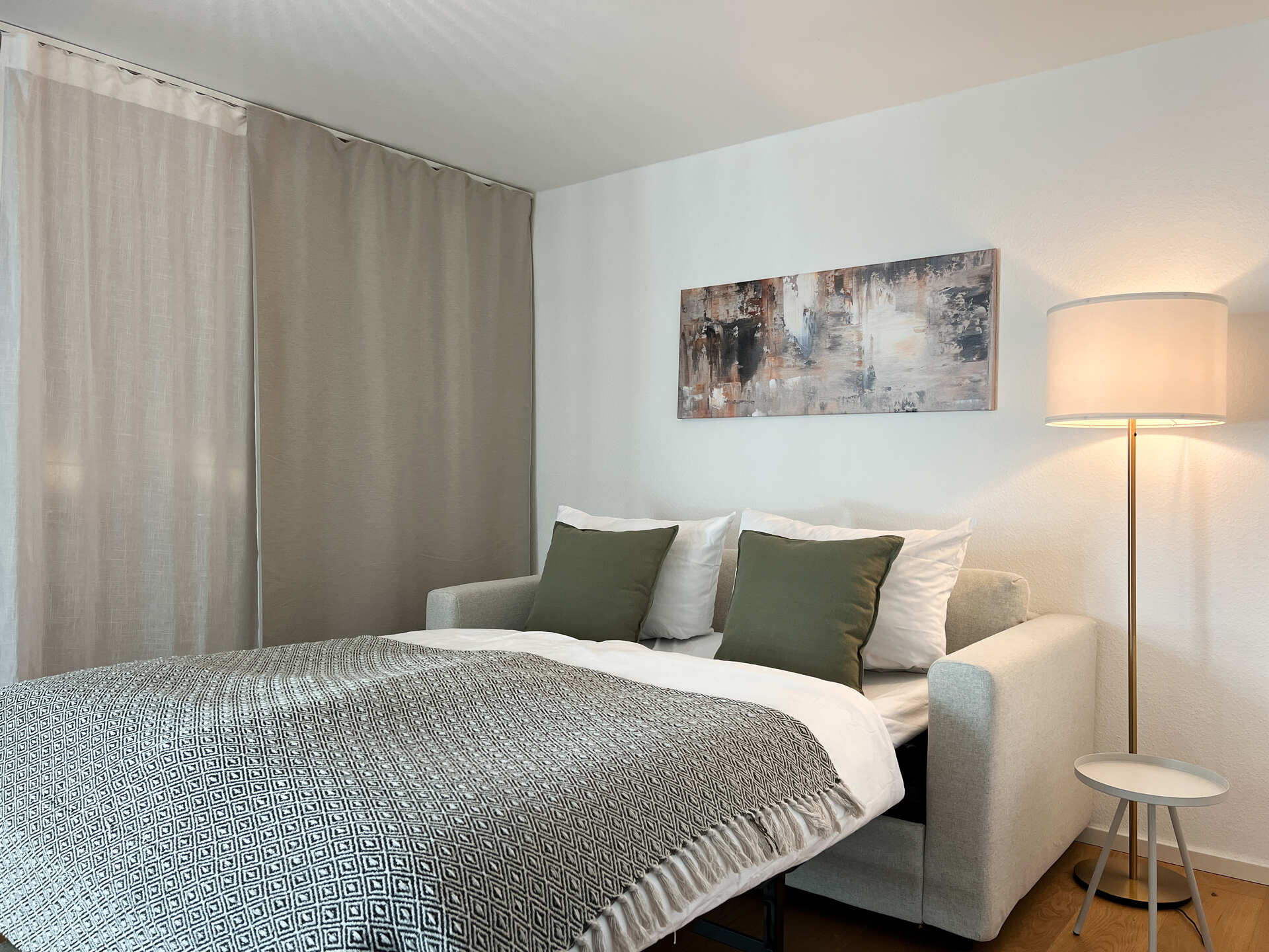 Ausgezogenes Schlafsofa mit Lampe