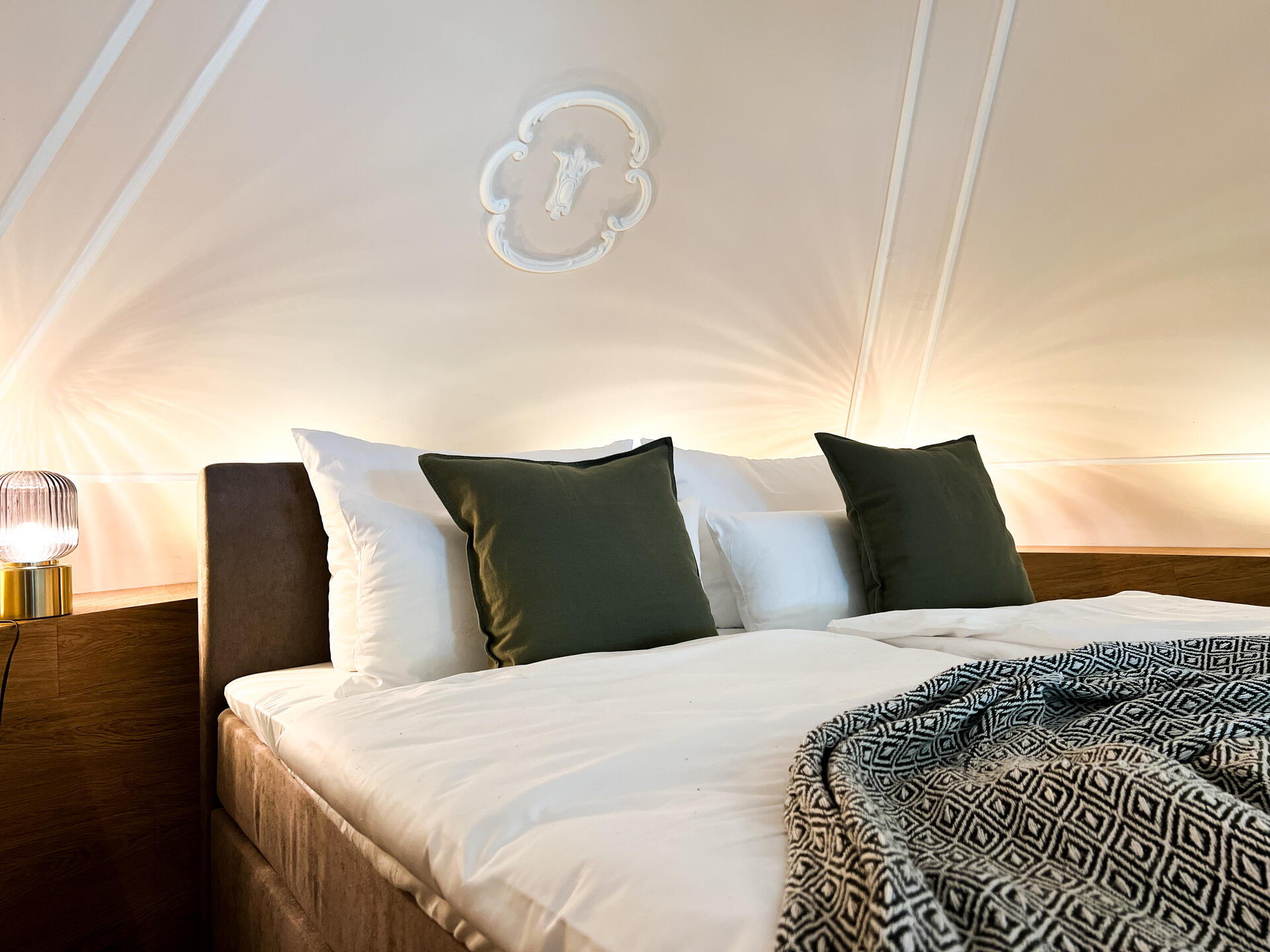 Detailaufnahme vom Bett mit Wanddekor