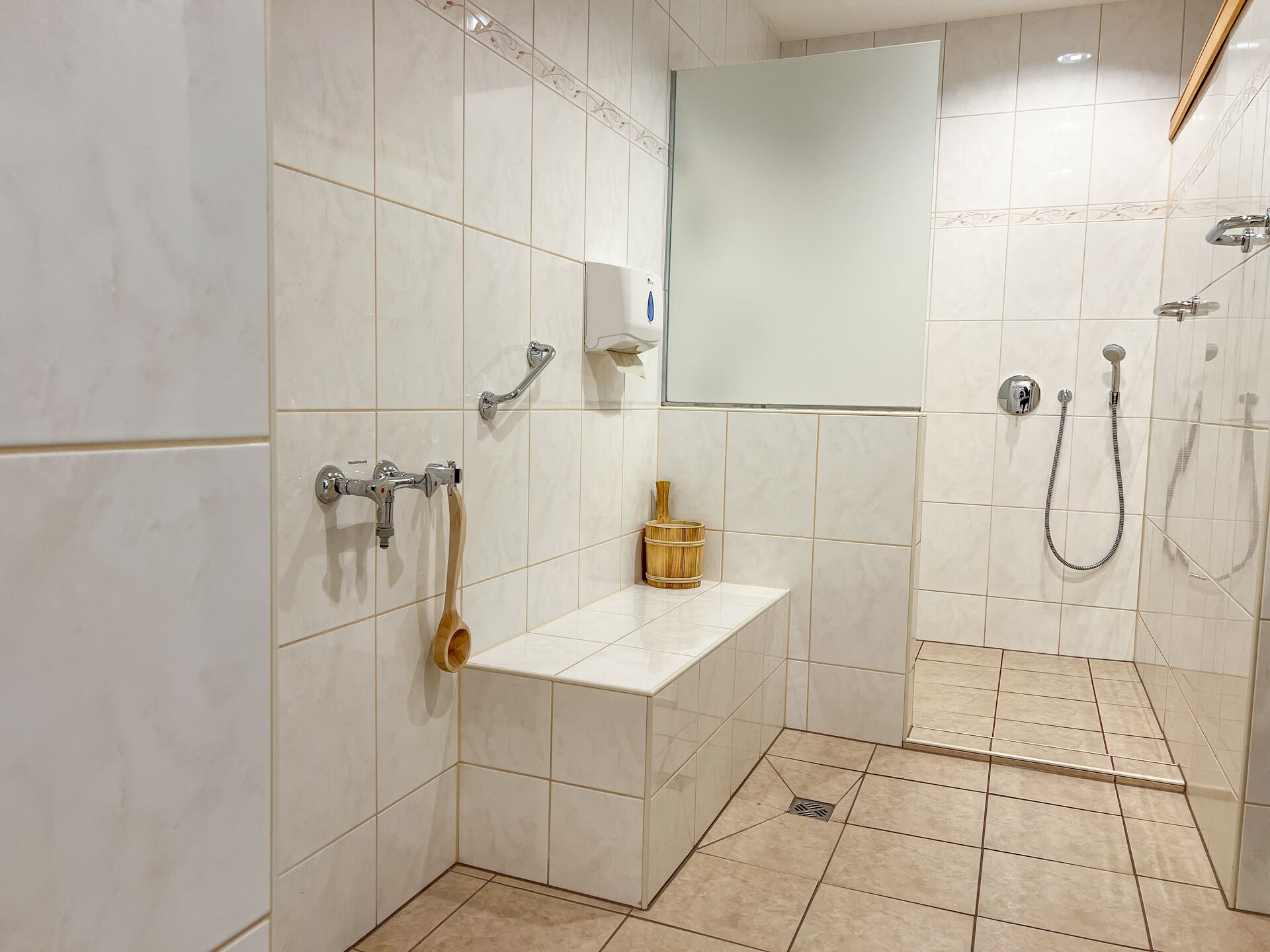 Dusche und Sitzbank im Saunabereich