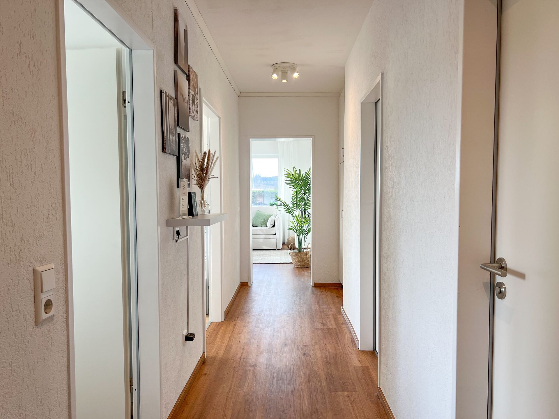 Flur mit Holzfussboden und Blick ins Wohnzimmer