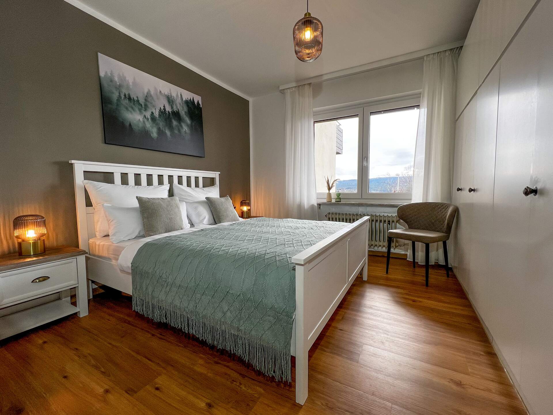 Schlafzimmer mit Doppelbett und Waldbild