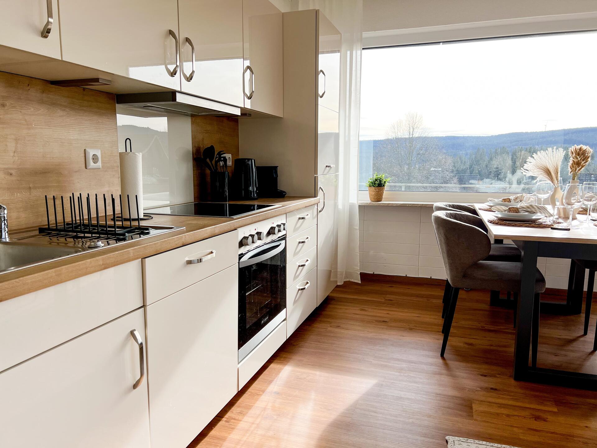 Moderne Kueche mit Esstisch und Ausblick