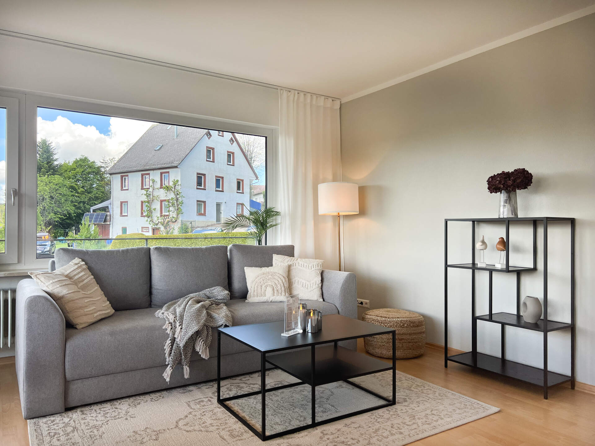 Graues Sofa mit Regal und Stehlampe