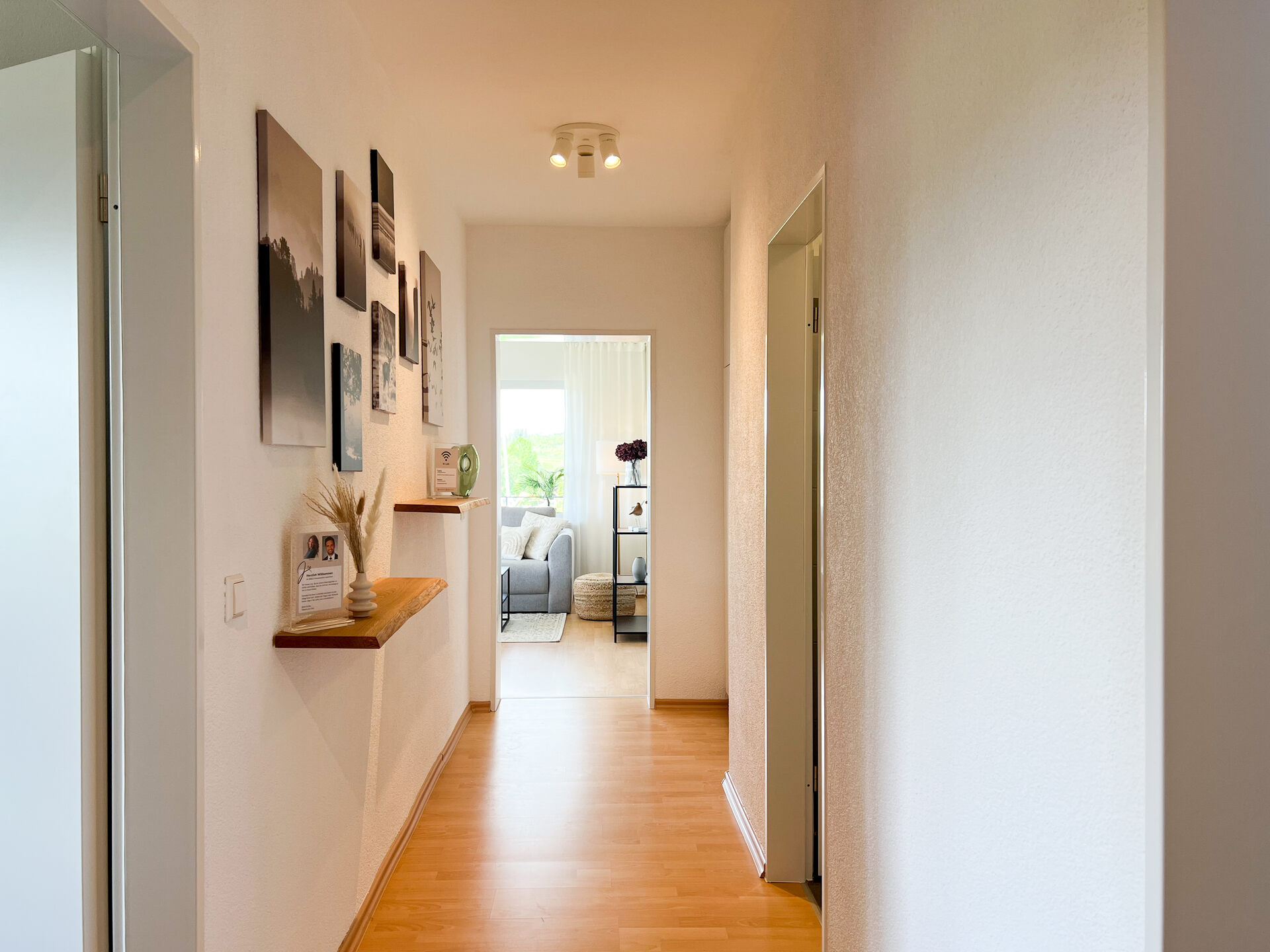 Flur mit Wandbildern und Blick ins Wohnzimmer